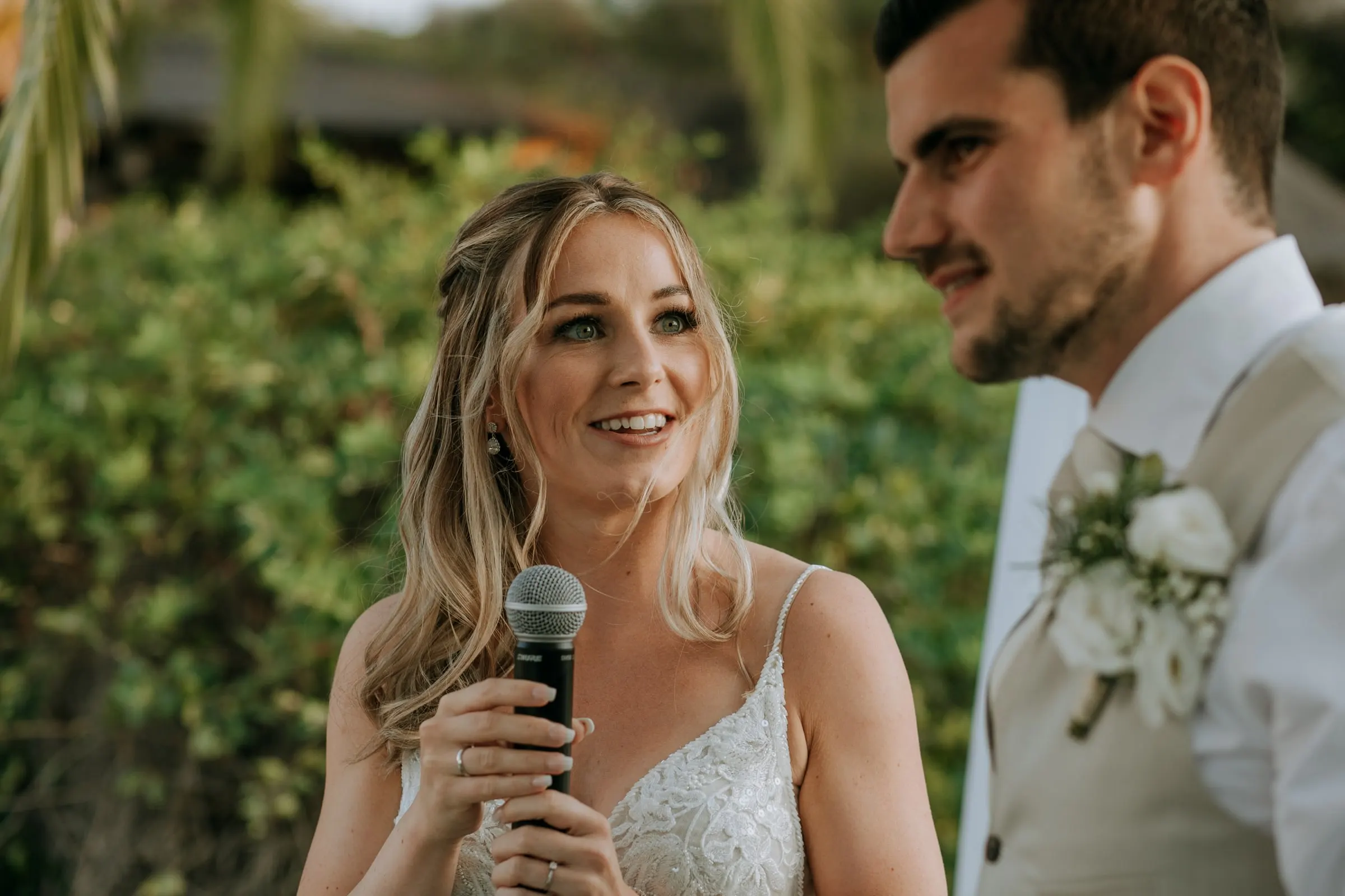 La novia da un discurso con el micrófono mientras el novio sonríe a su lado, Hacienda San José, Mijas