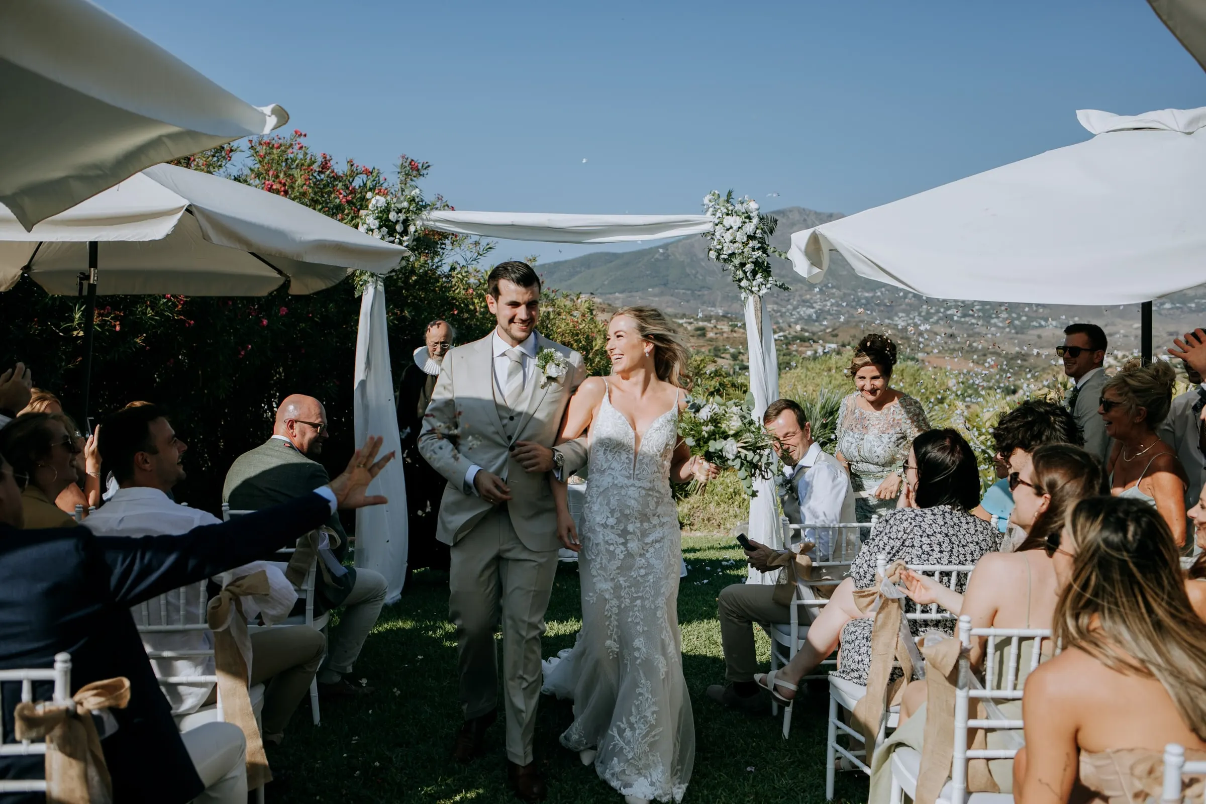 Los novios recorren el pasillo mientras los invitados alargan la mano para felicitarles, Hacienda San José, Mijas