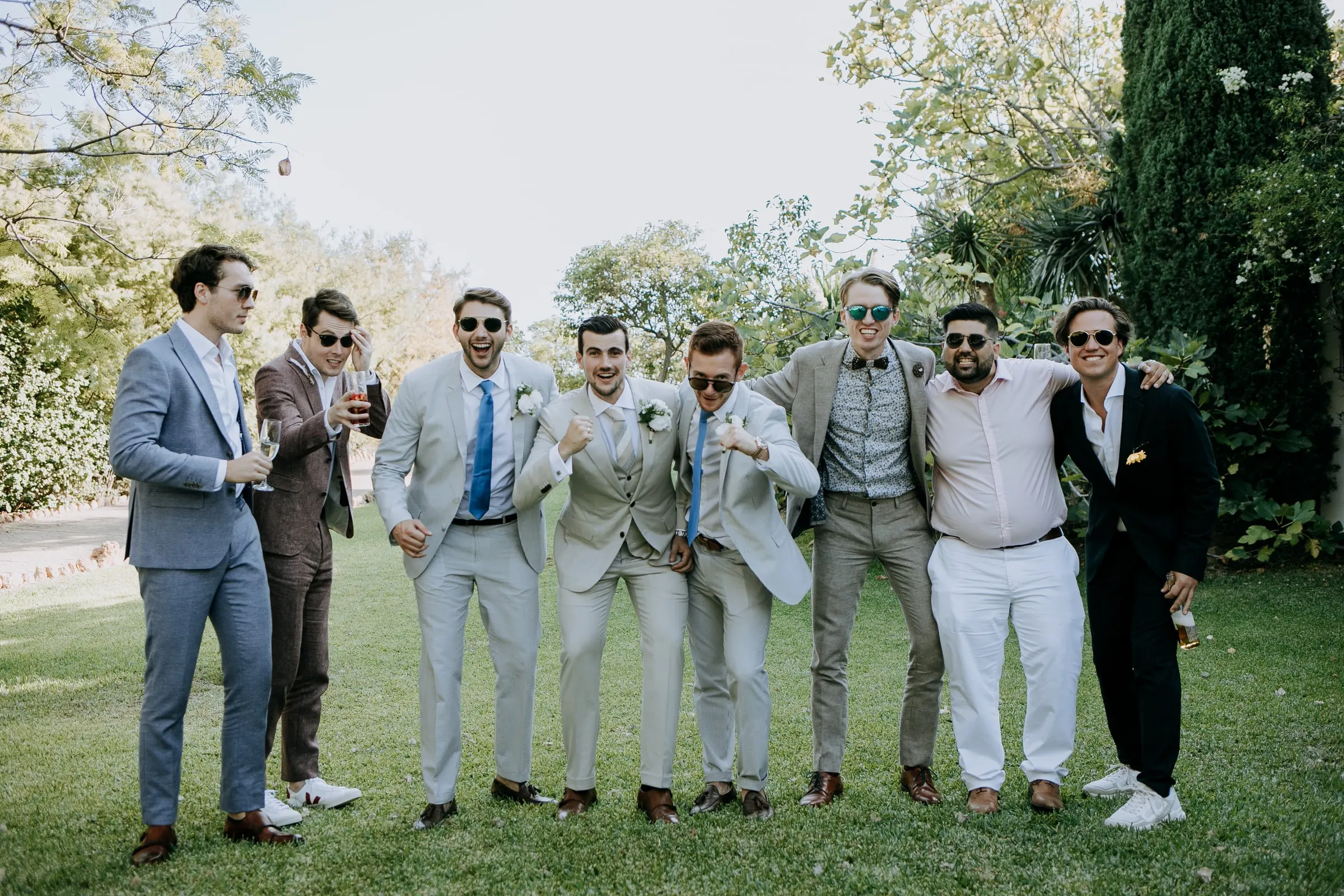 El novio y sus amigos, con traje y gafas de sol, posan haciendo el tonto en el césped, Hacienda San José, Mijas