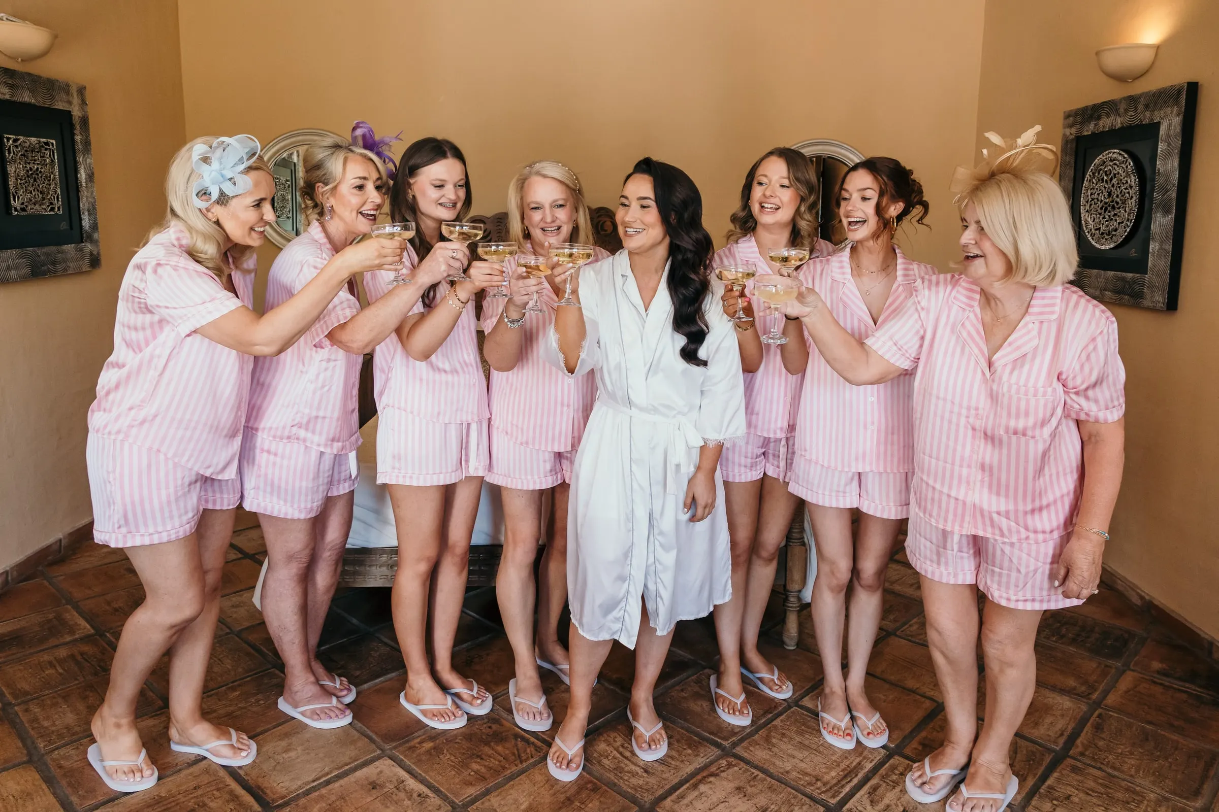 Novia y damas en pijama rosa brindando con copas, Hacienda San José