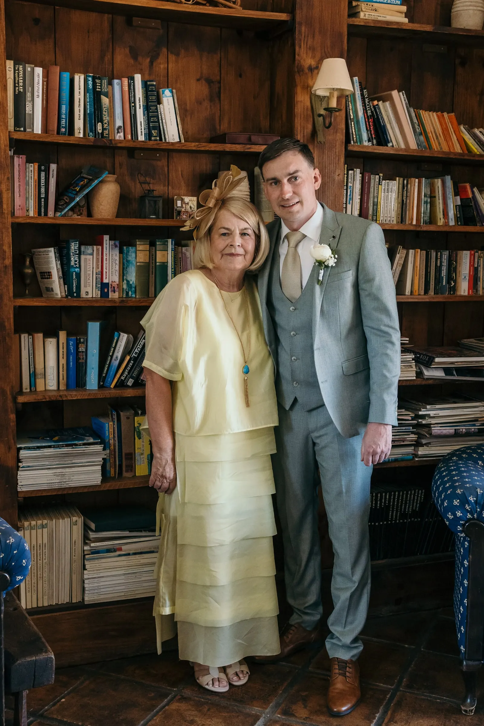 El novio con una invitada de vestido amarillo pálido entre estanterías, Mijas