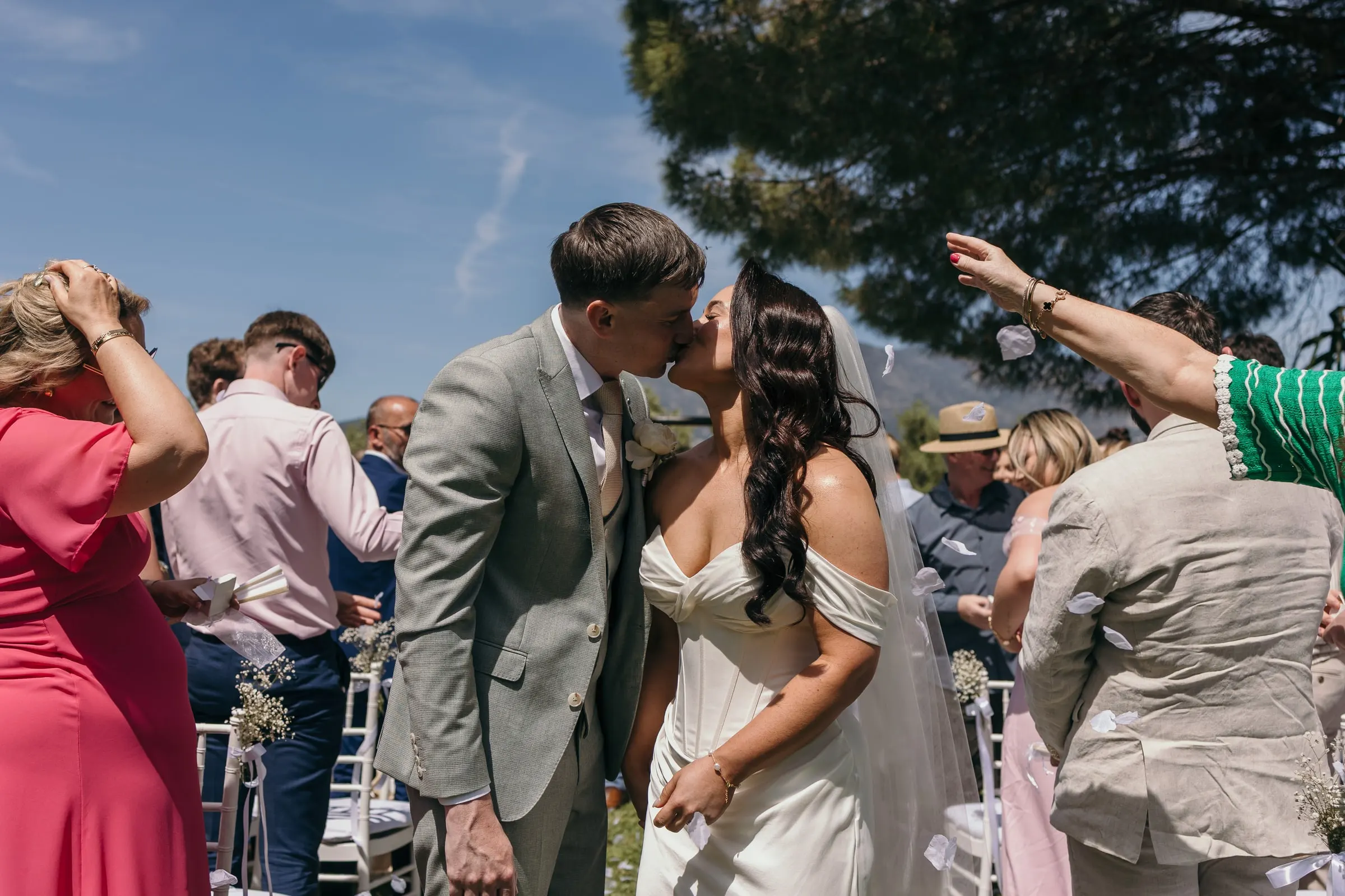 Los recién casados se besan en el pasillo mientras los invitados les lanzan pétalos, Mijas