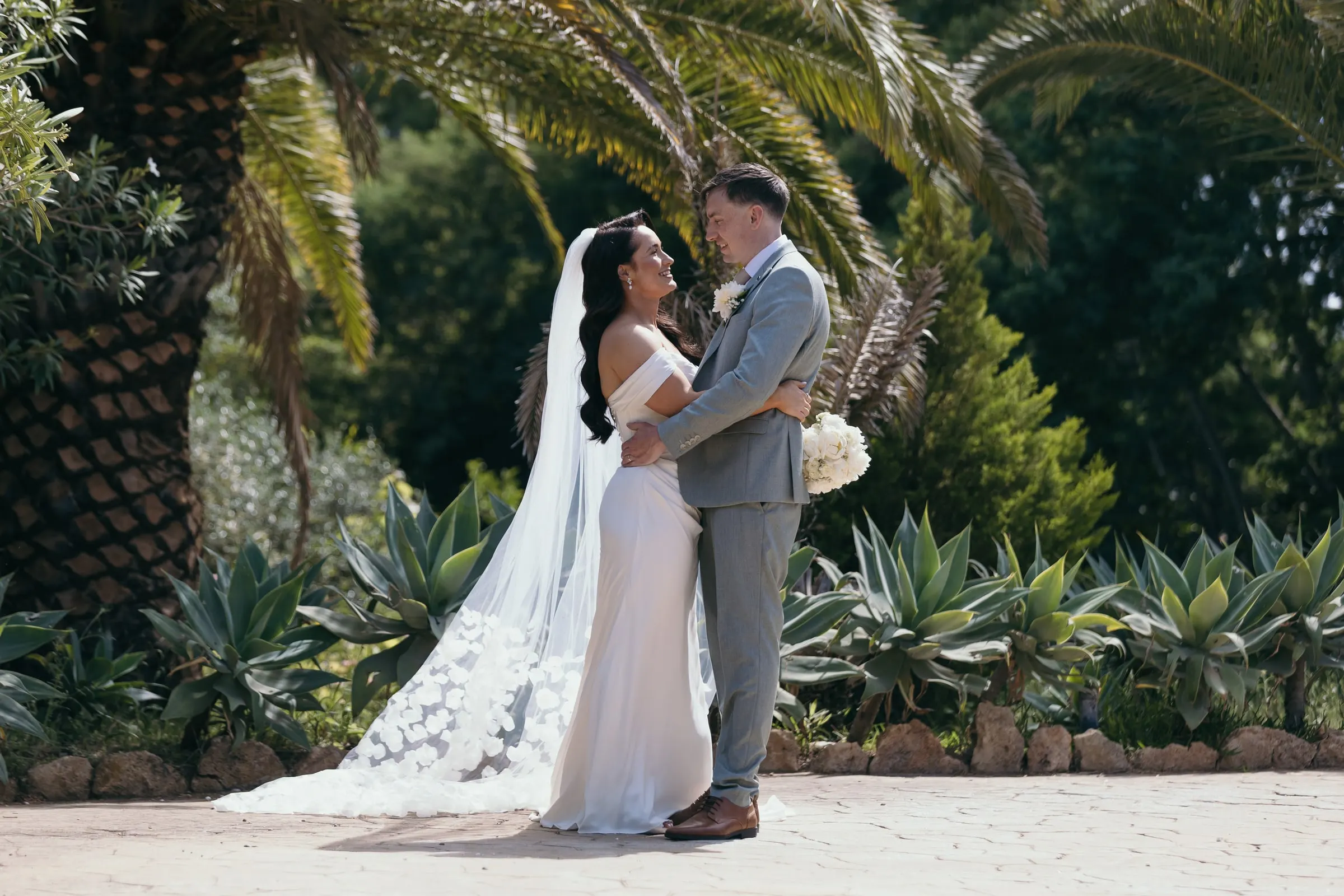 Los recién casados abrazados entre las palmeras y los agaves del jardín, Hacienda San José, Mijas