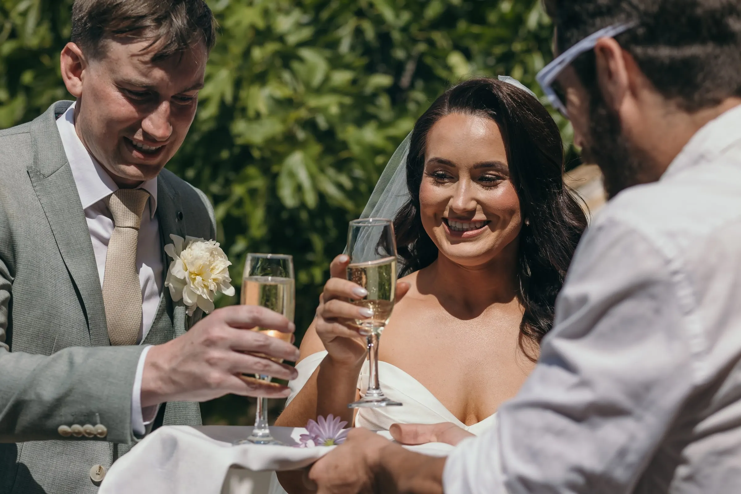 Los novios brindan con un amigo en el cóctel