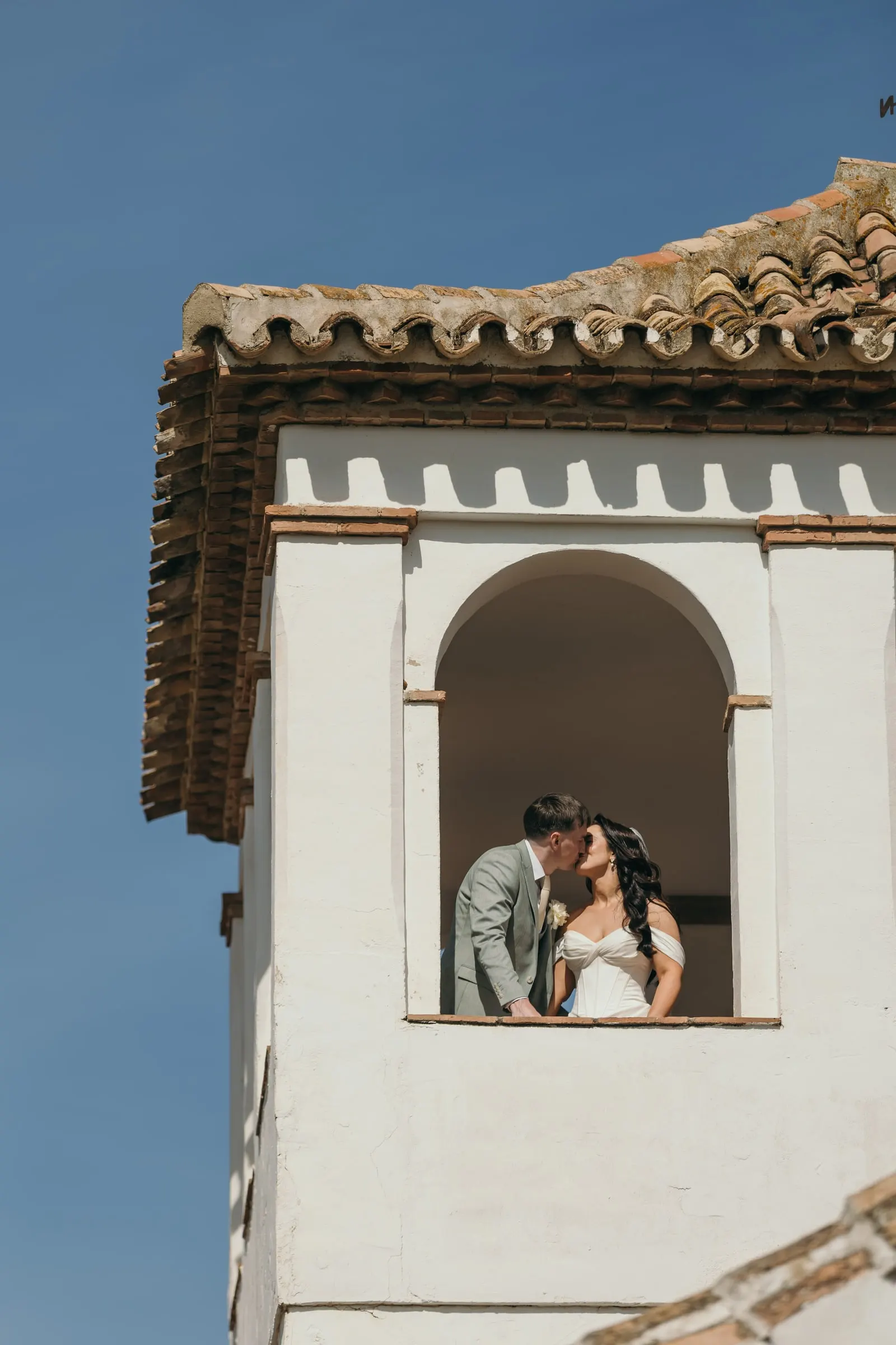 Los novios se besan en la ventana en arco de la torre blanca, Hacienda San José