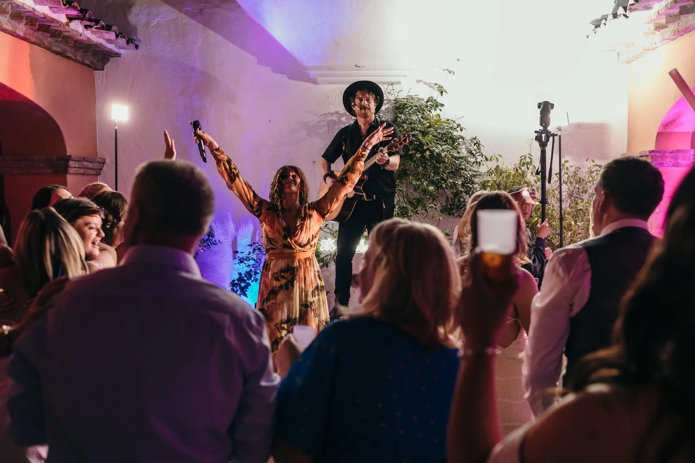La cantante de la banda abre los brazos ante los invitados que bailan en el patio, Mijas