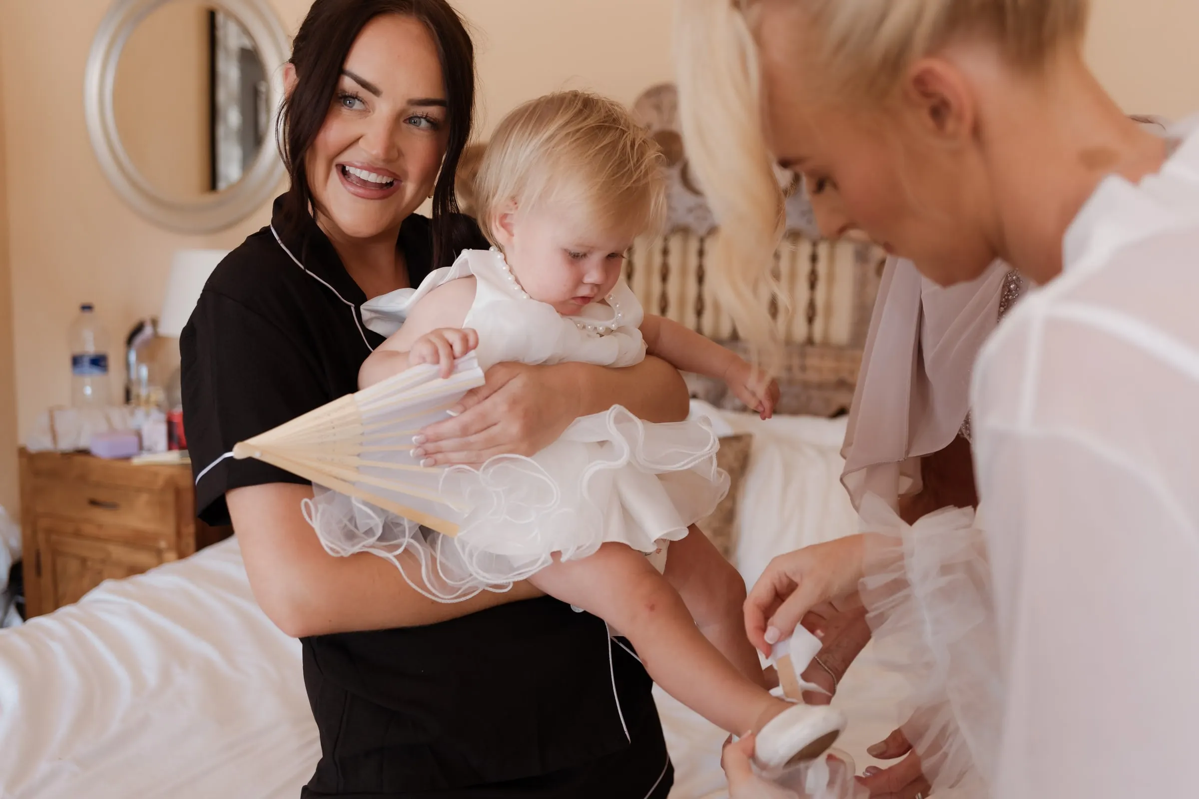 Bridesmaid holding the baby while the bride gets ready