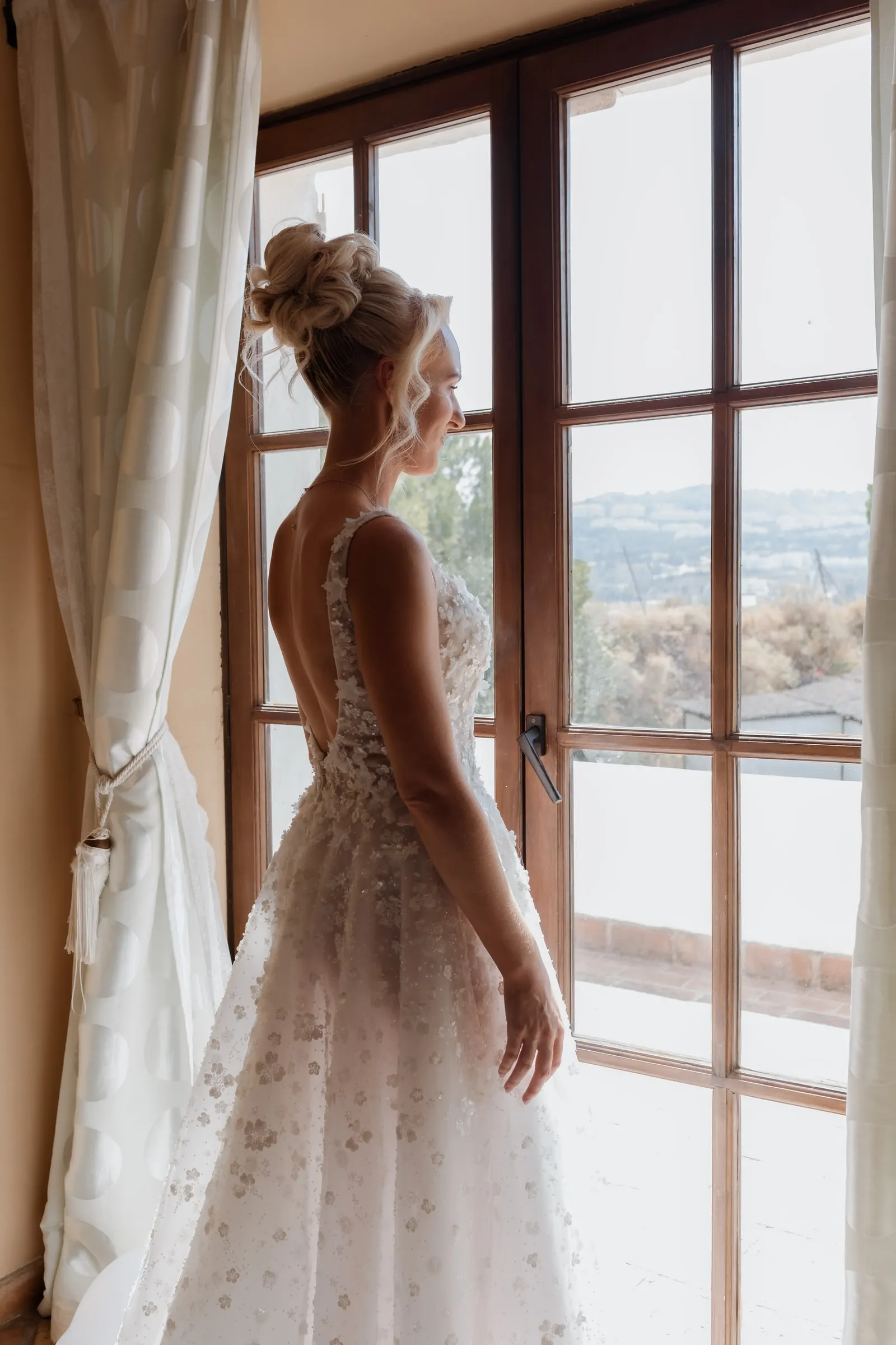 Bride by tall glass doors looking out over the Mijas countryside
