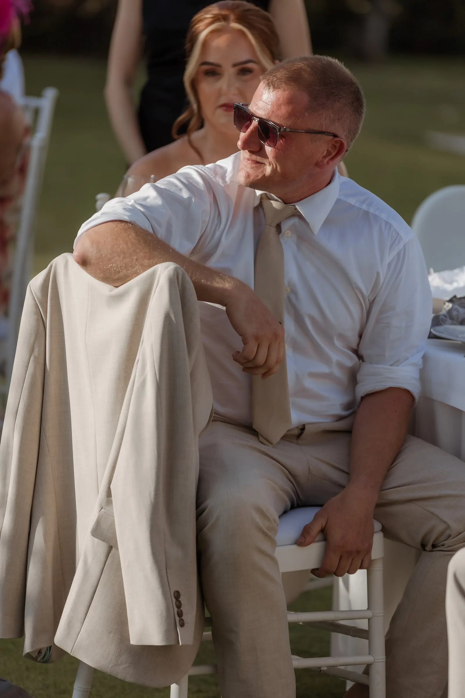 Guest in sunglasses relaxing at the table with his jacket over the chair