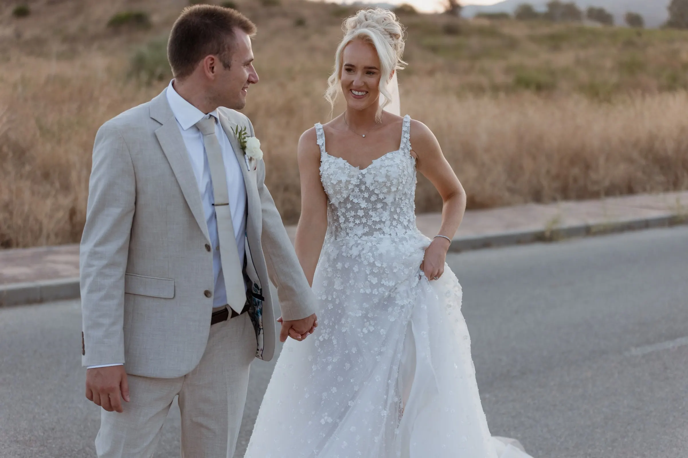Newlyweds laughing as they walk along the road in the hills above Mijas