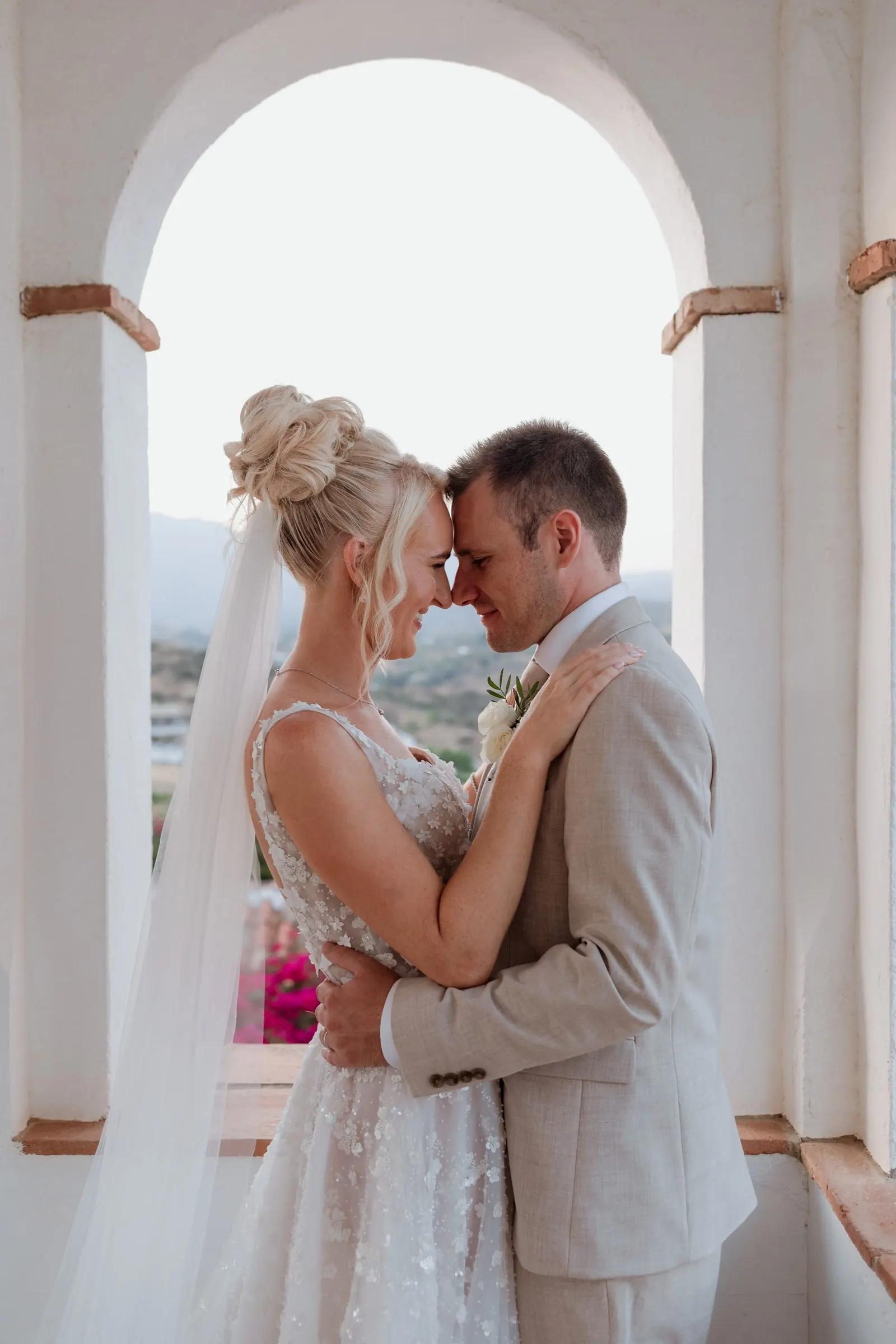 Los novios frente con frente bajo un arco blanco, Mijas
