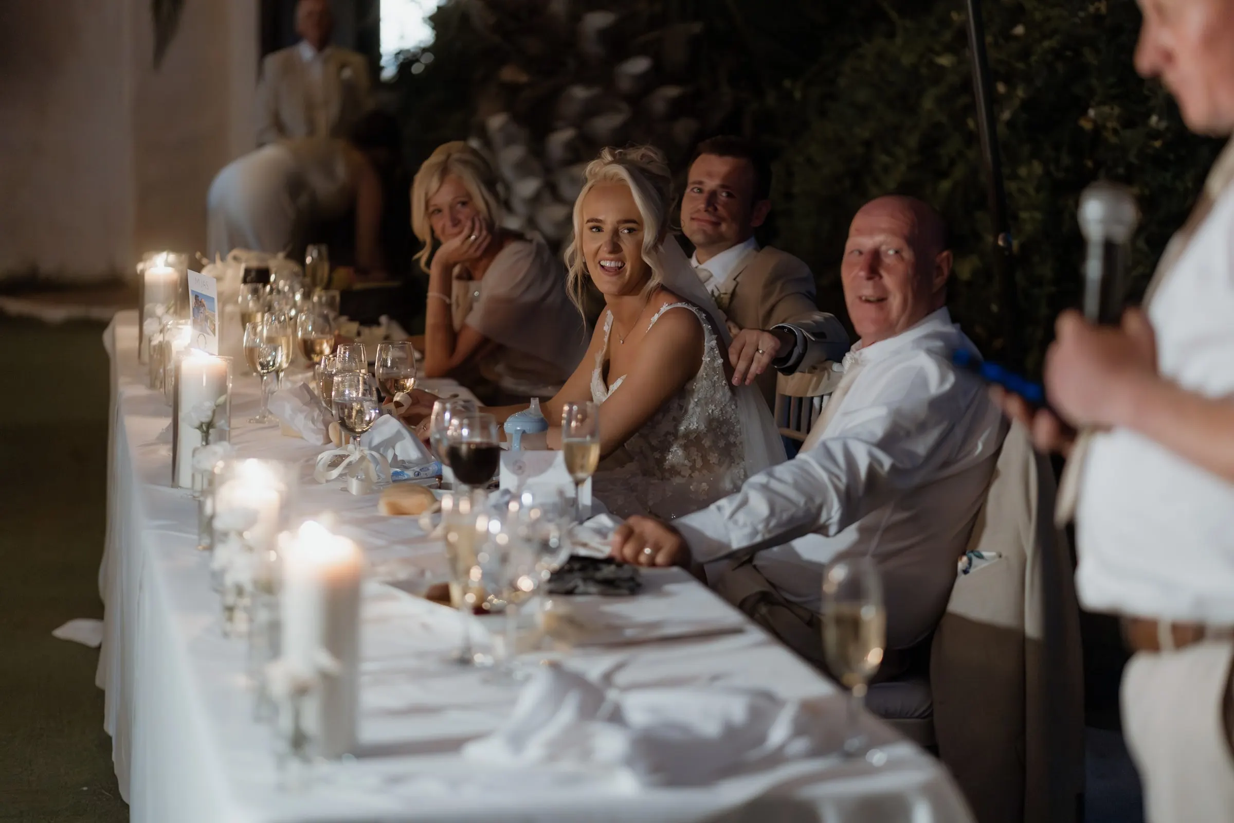 Bride laughing at the candlelit top table during the speeches