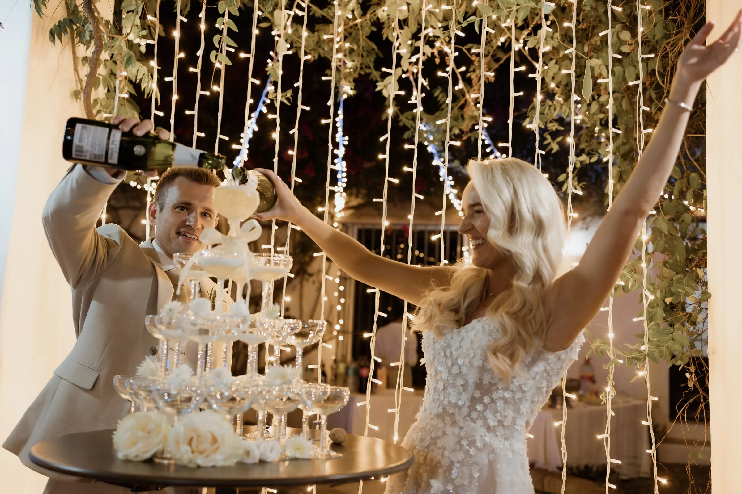 Groom pouring the champagne tower as the bride cheers, Mijas
