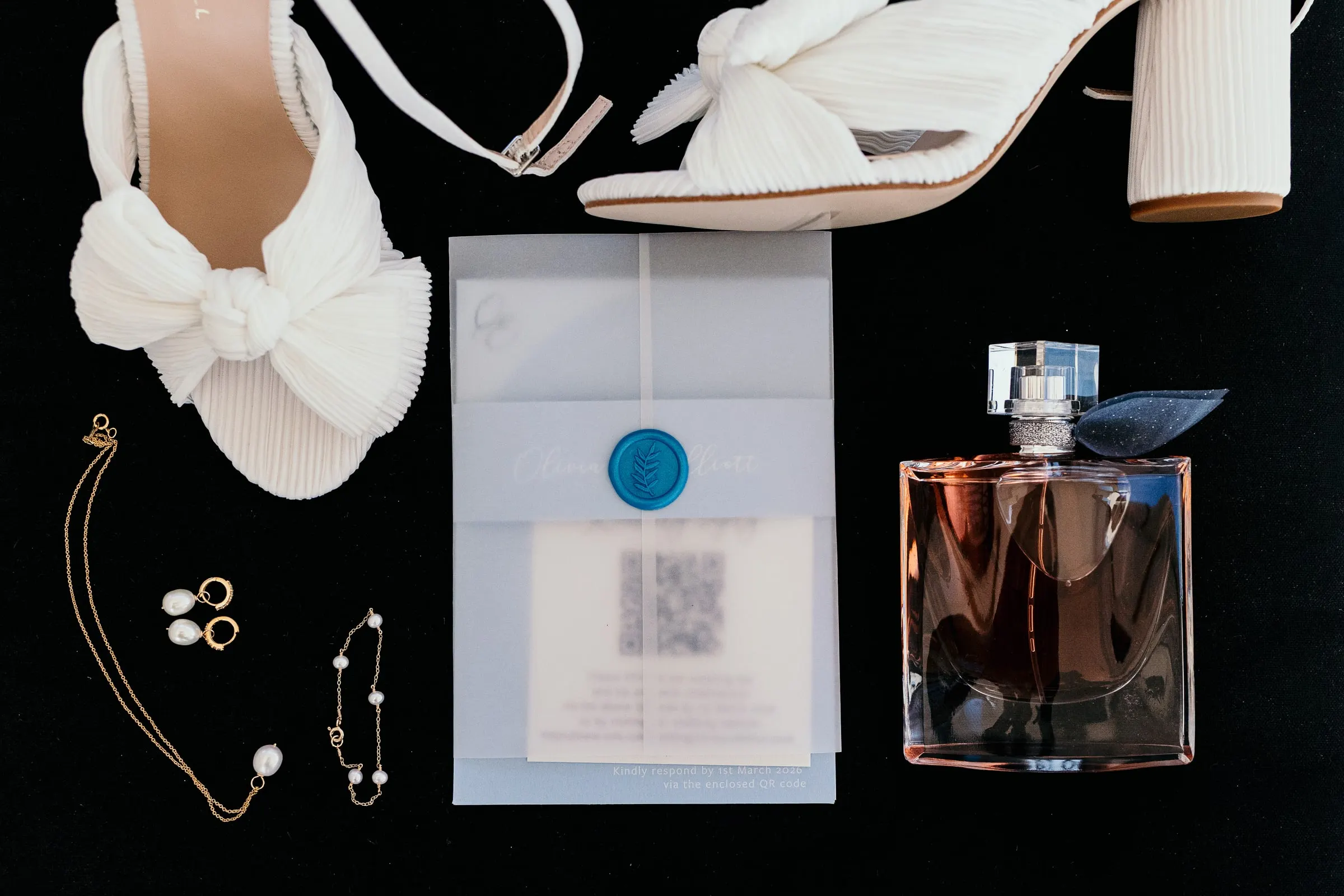 Bridal shoes, perfume, jewellery and invitation laid out for the wedding day in Mijas