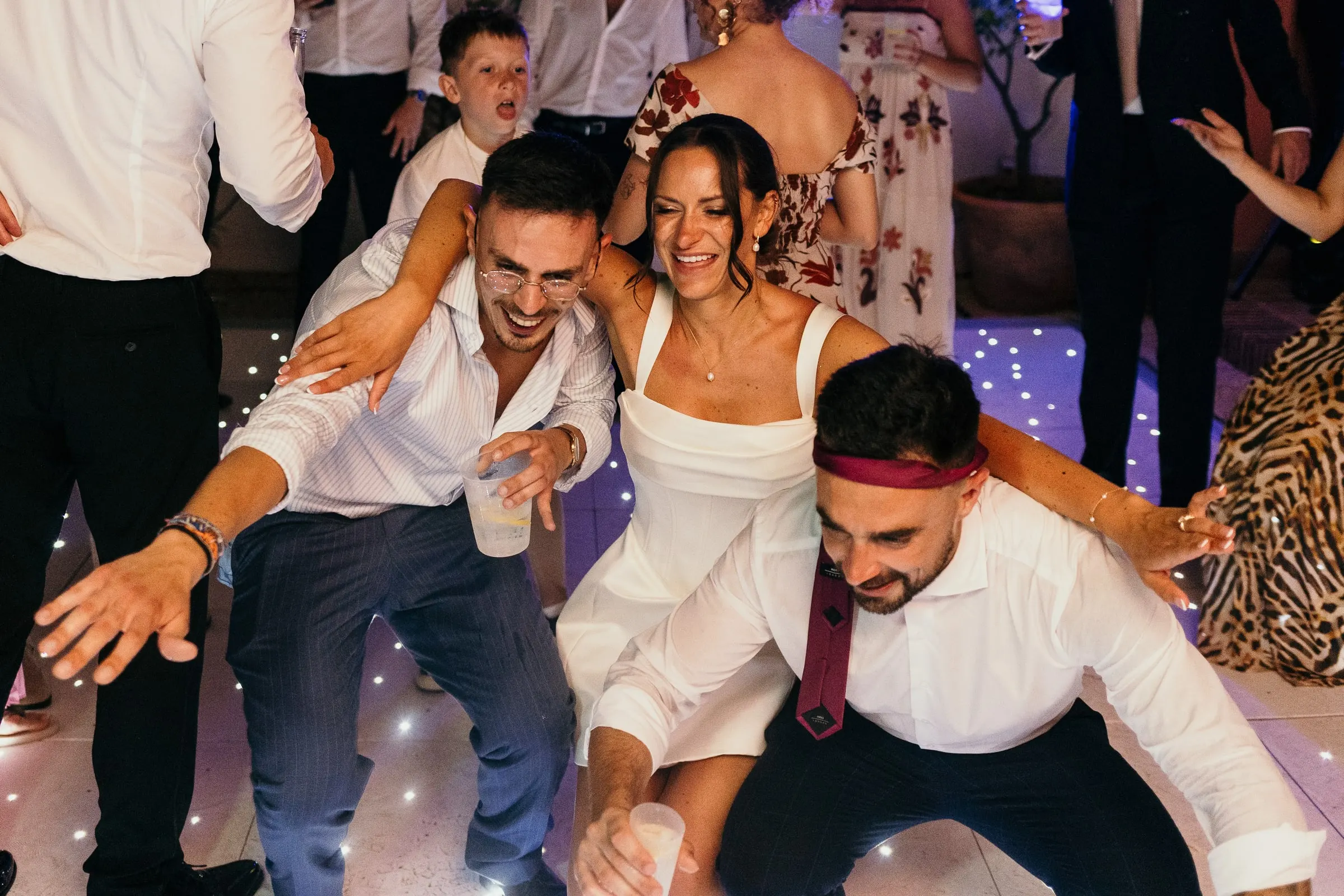 Bride in the middle of the dance floor surrounded by friends