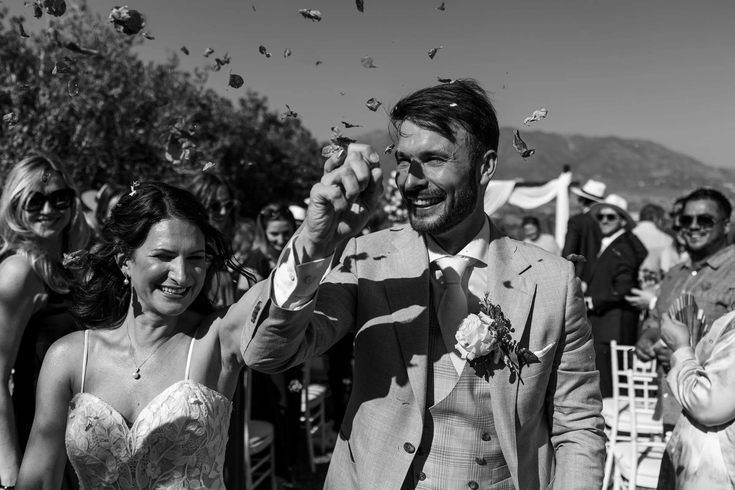 Los recién casados se ríen entre confeti al salir de la ceremonia, en blanco y negro, Hacienda San José, Mijas