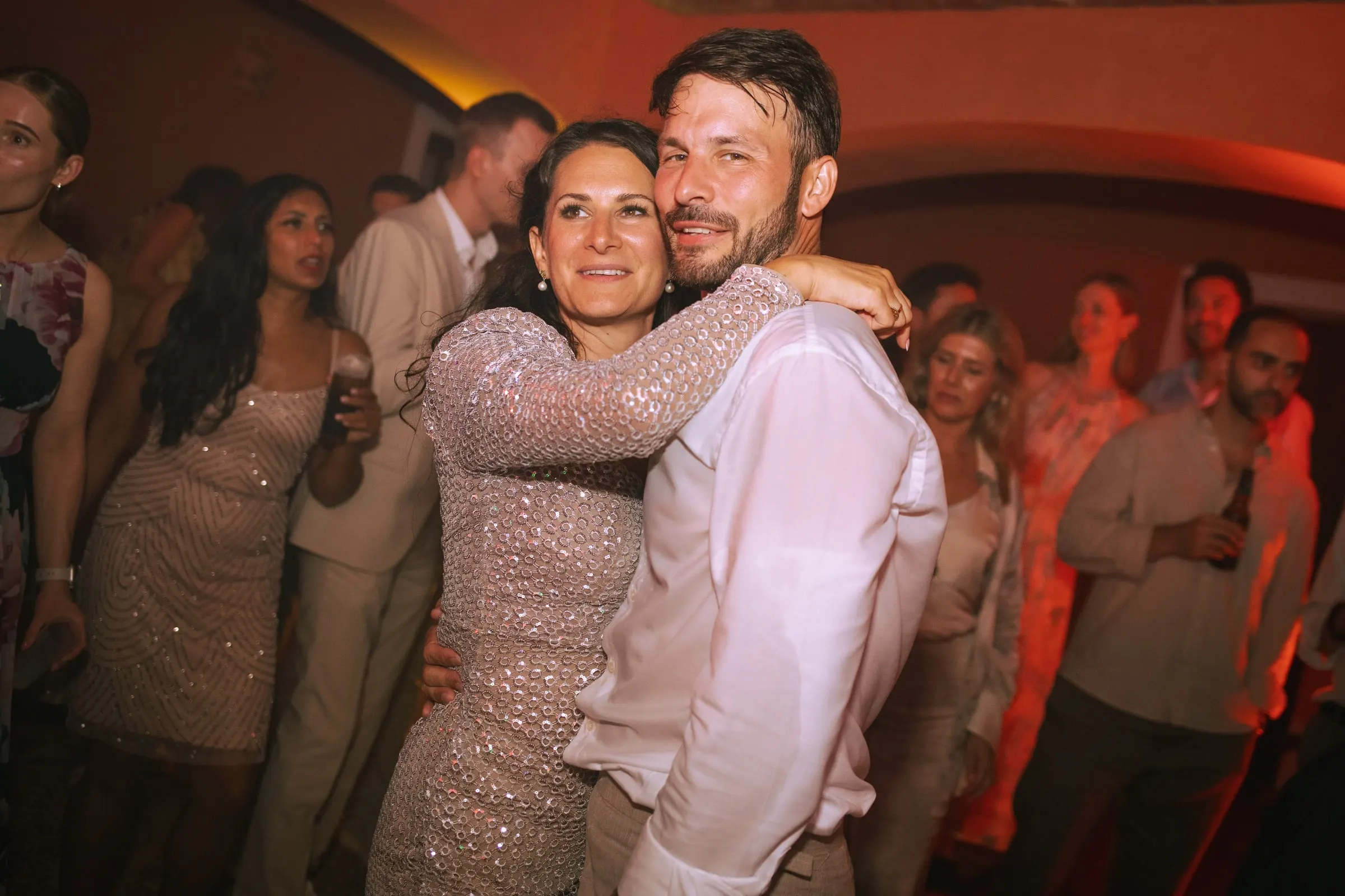 El novio baila mejilla con mejilla con una invitada de lentejuelas en la fiesta, Hacienda San José, Mijas