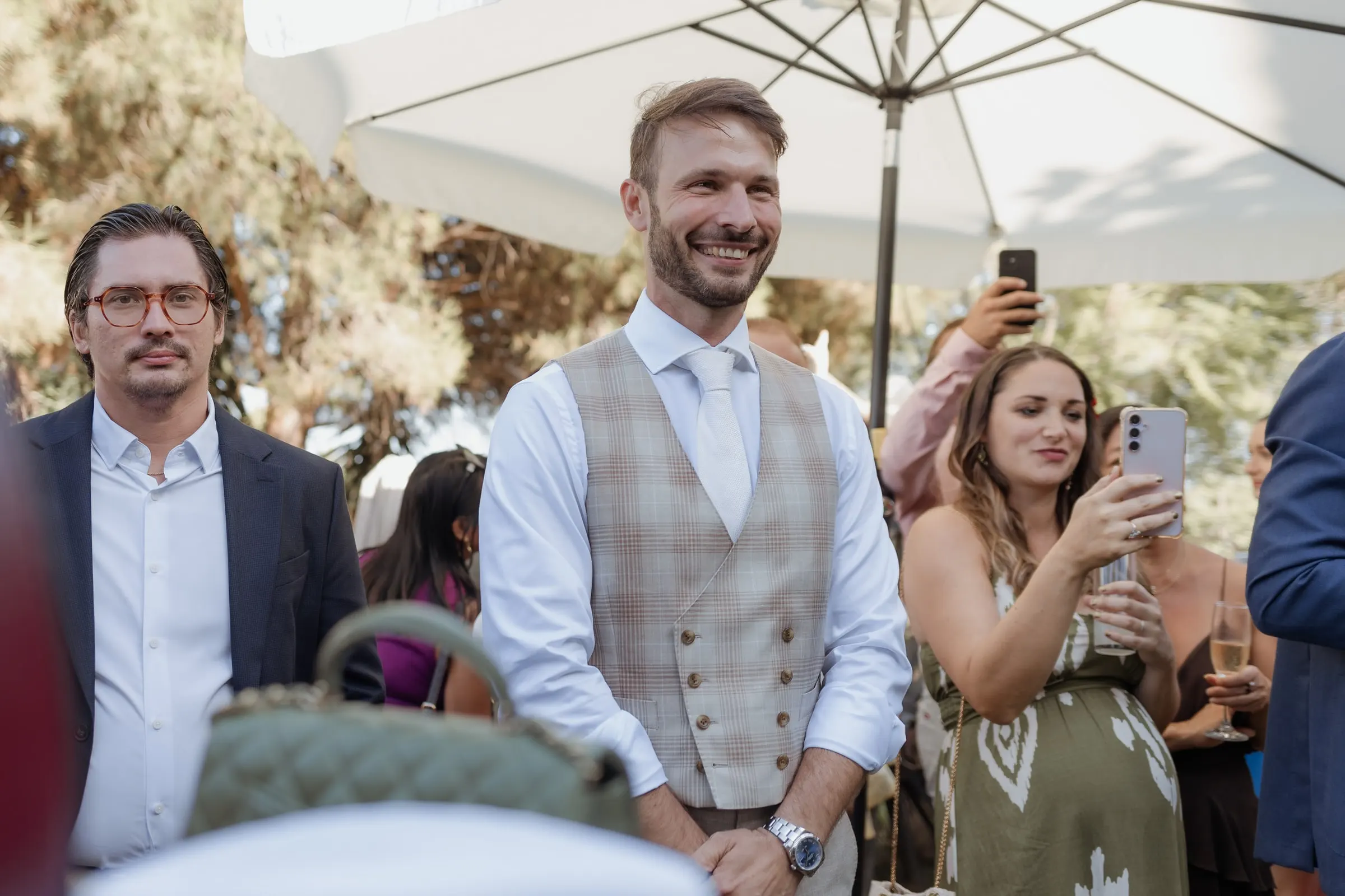 El novio, con chaleco de tweed, sonríe mientras los invitados graban con el móvil, Hacienda San José, Mijas