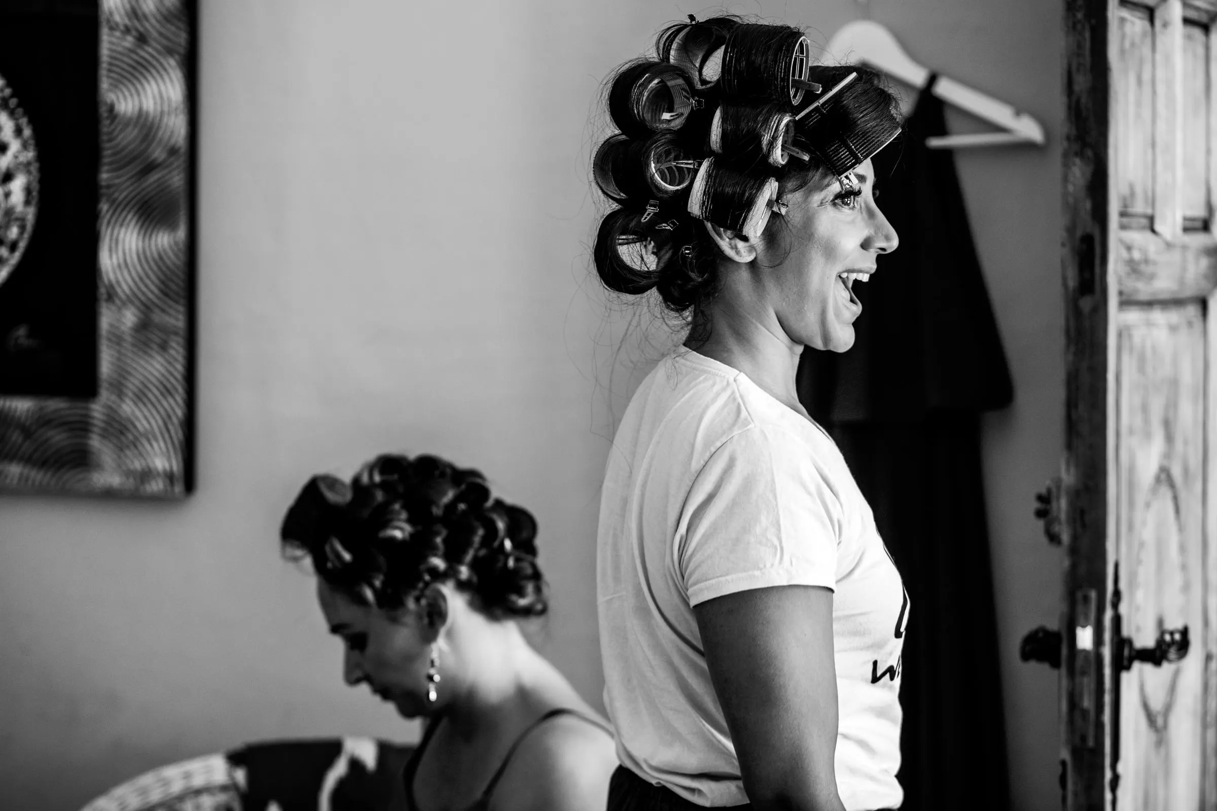 Dos mujeres con rulos se ríen mientras se preparan, en blanco y negro, Hacienda San José, Mijas