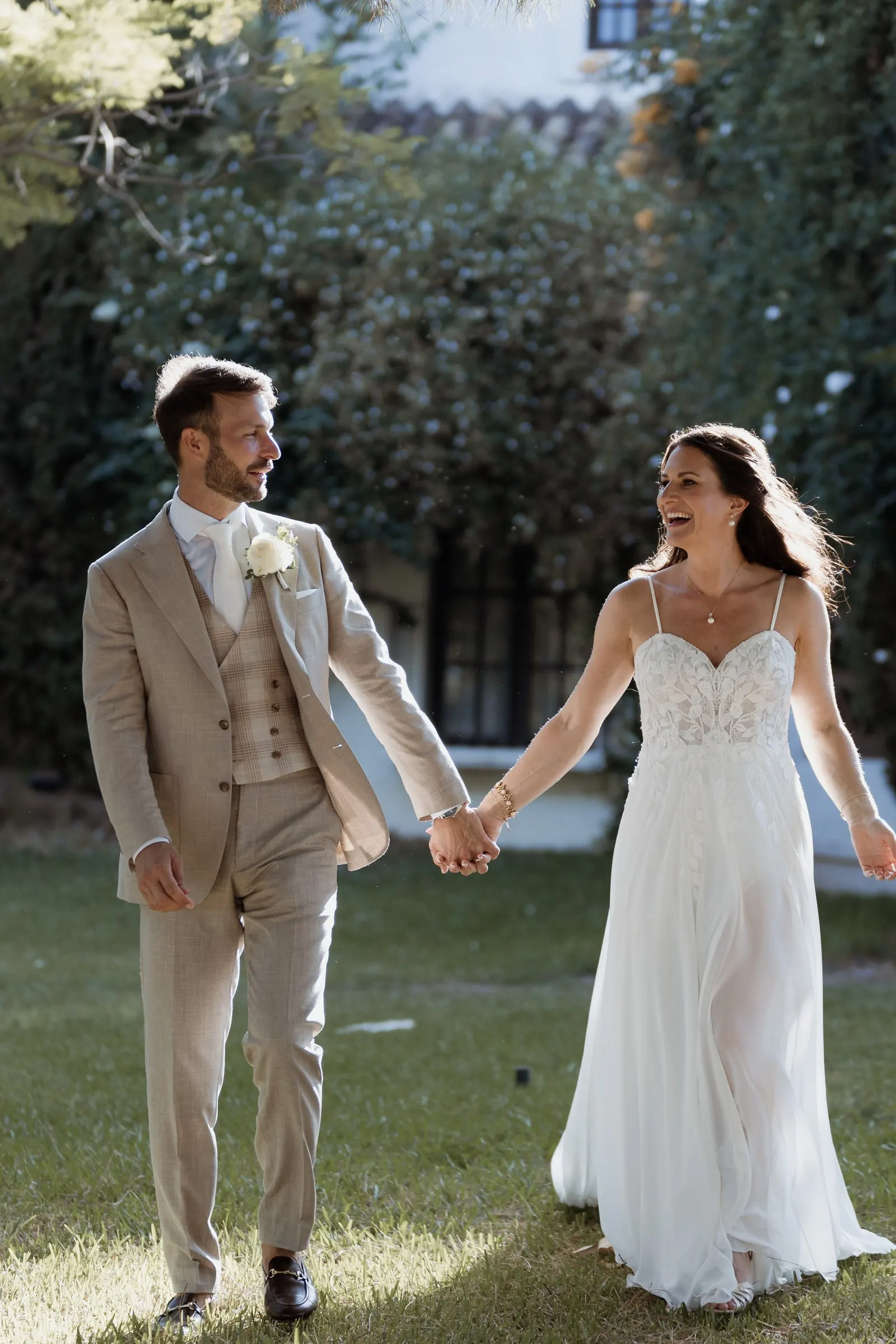 Los novios se ríen mientras cruzan el césped de la mano, Hacienda San José, Mijas