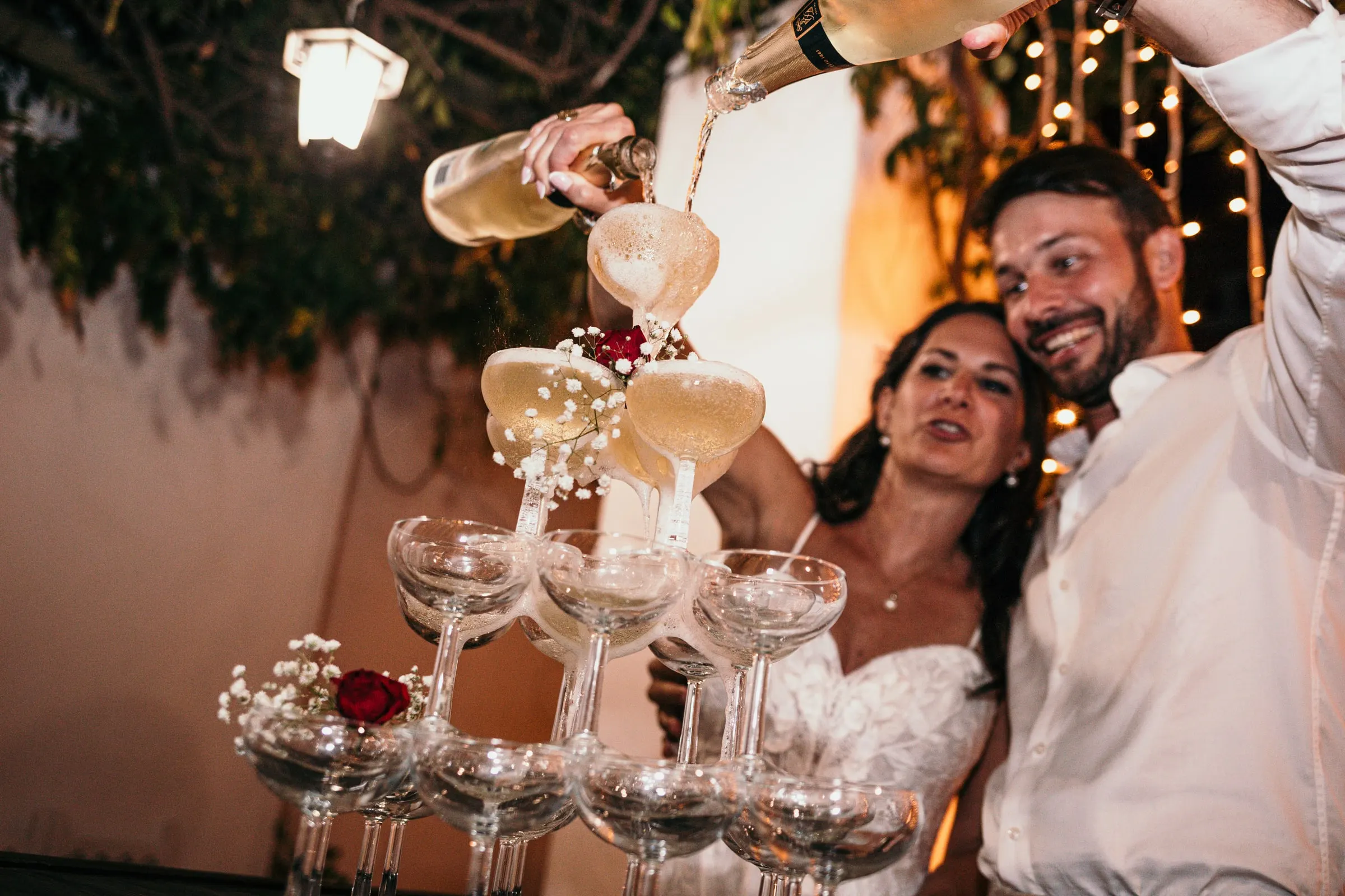 Los novios vierten champán sobre una torre de copas por la noche, Hacienda San José, Mijas