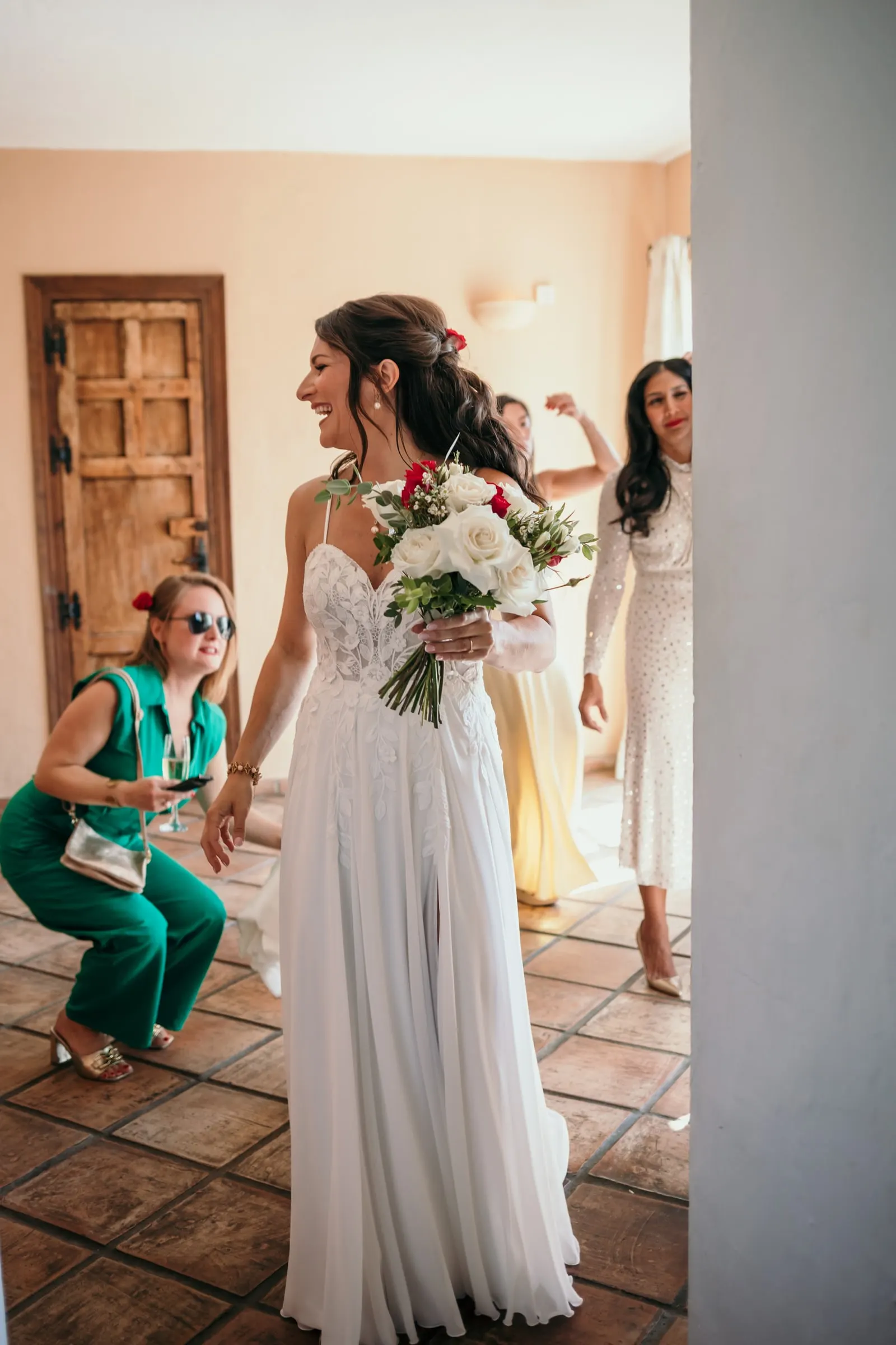 La novia sonríe con el ramo mientras sus amigas, entusiasmadas, se agachan a su lado, Hacienda San José, Mijas