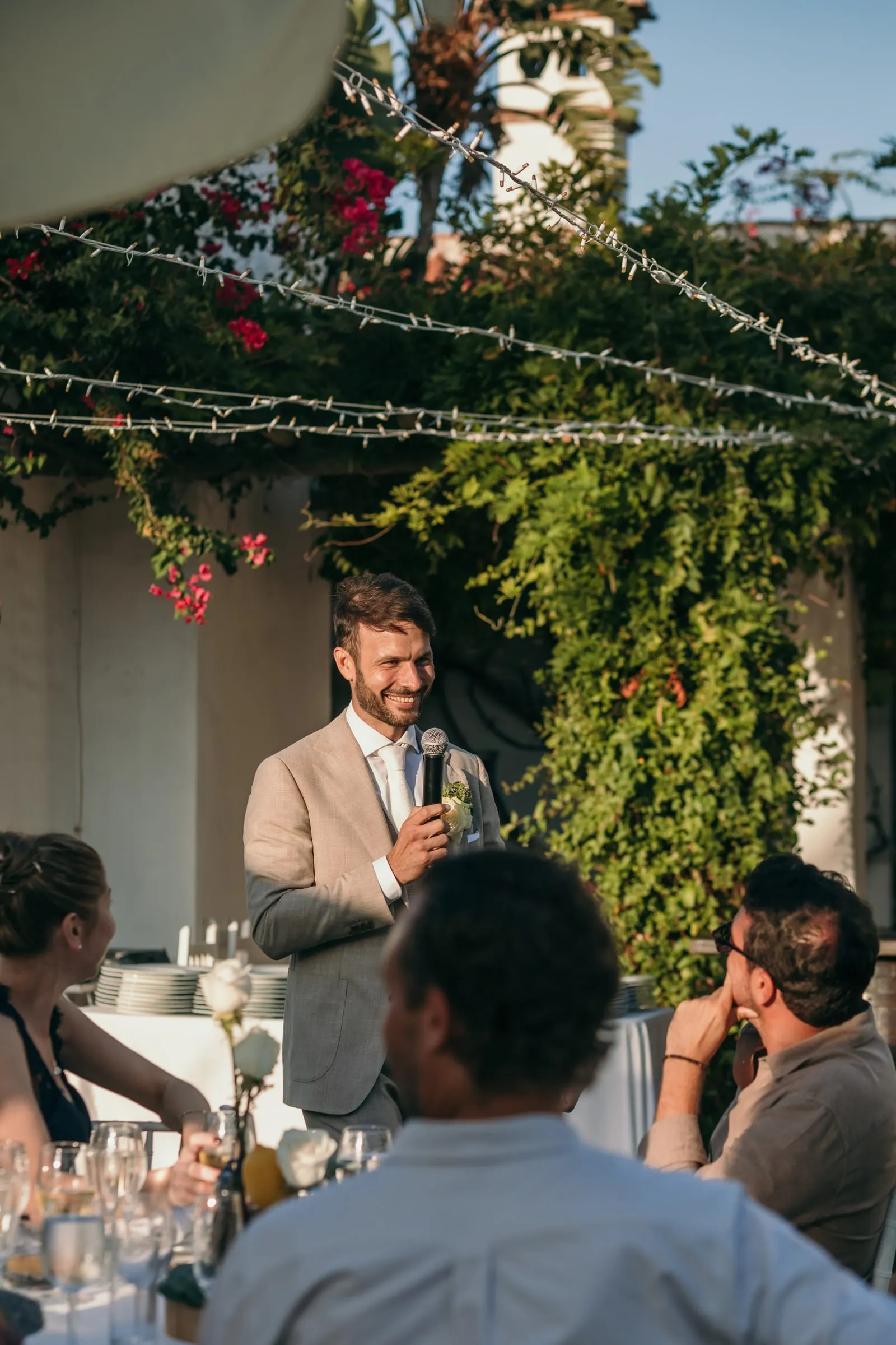 El novio da un discurso bajo la buganvilla mientras los invitados escuchan en sus mesas, Hacienda San José, Mijas