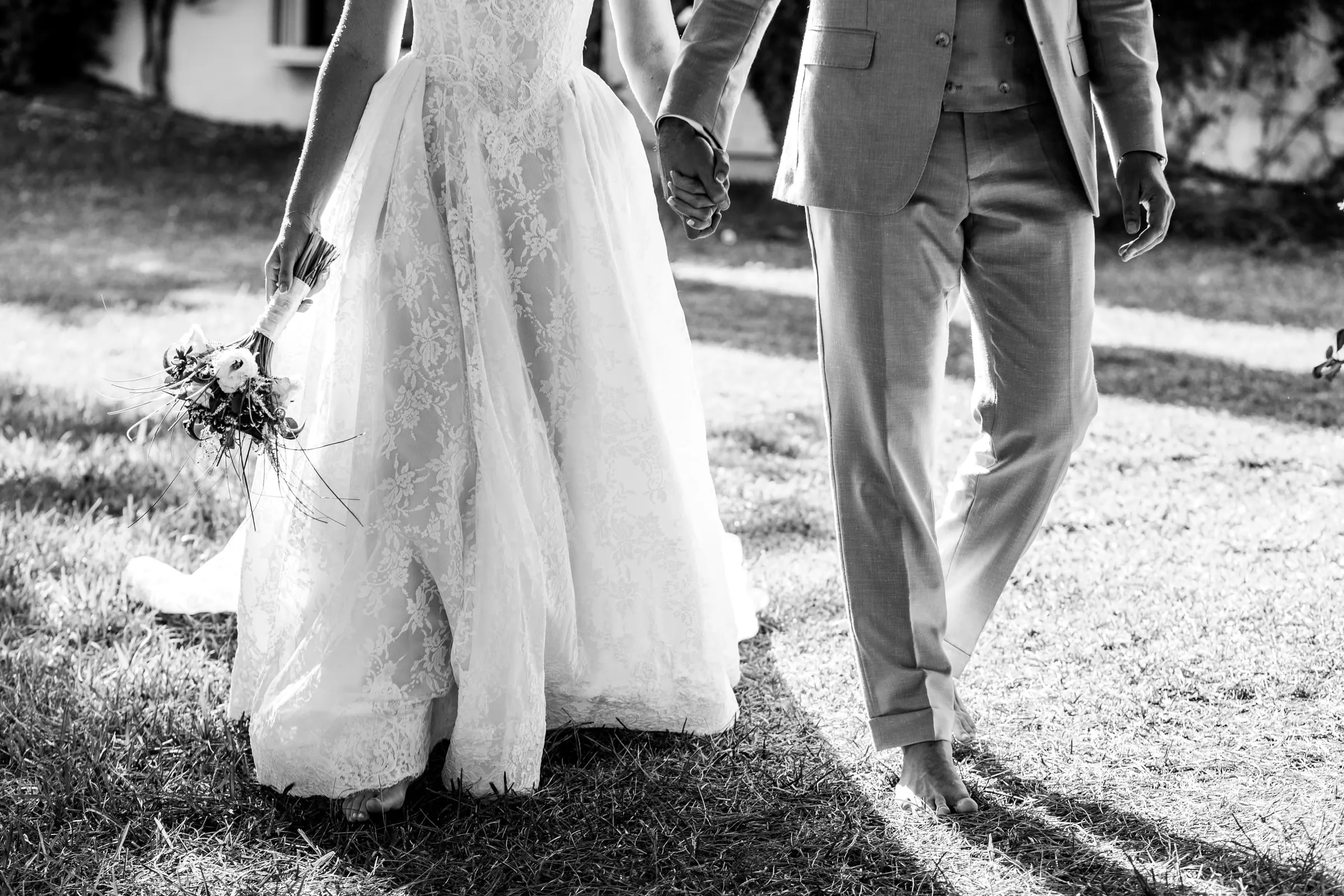 Black and white of the barefoot couple's legs and her lace skirt crossing the lawn, Hacienda San José, Mijas