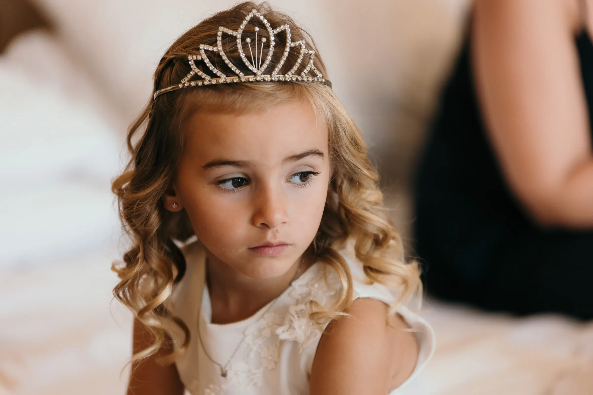 Close-up of the flower girl in a sparkling tiara gazing to one side, Hacienda San José, Mijas