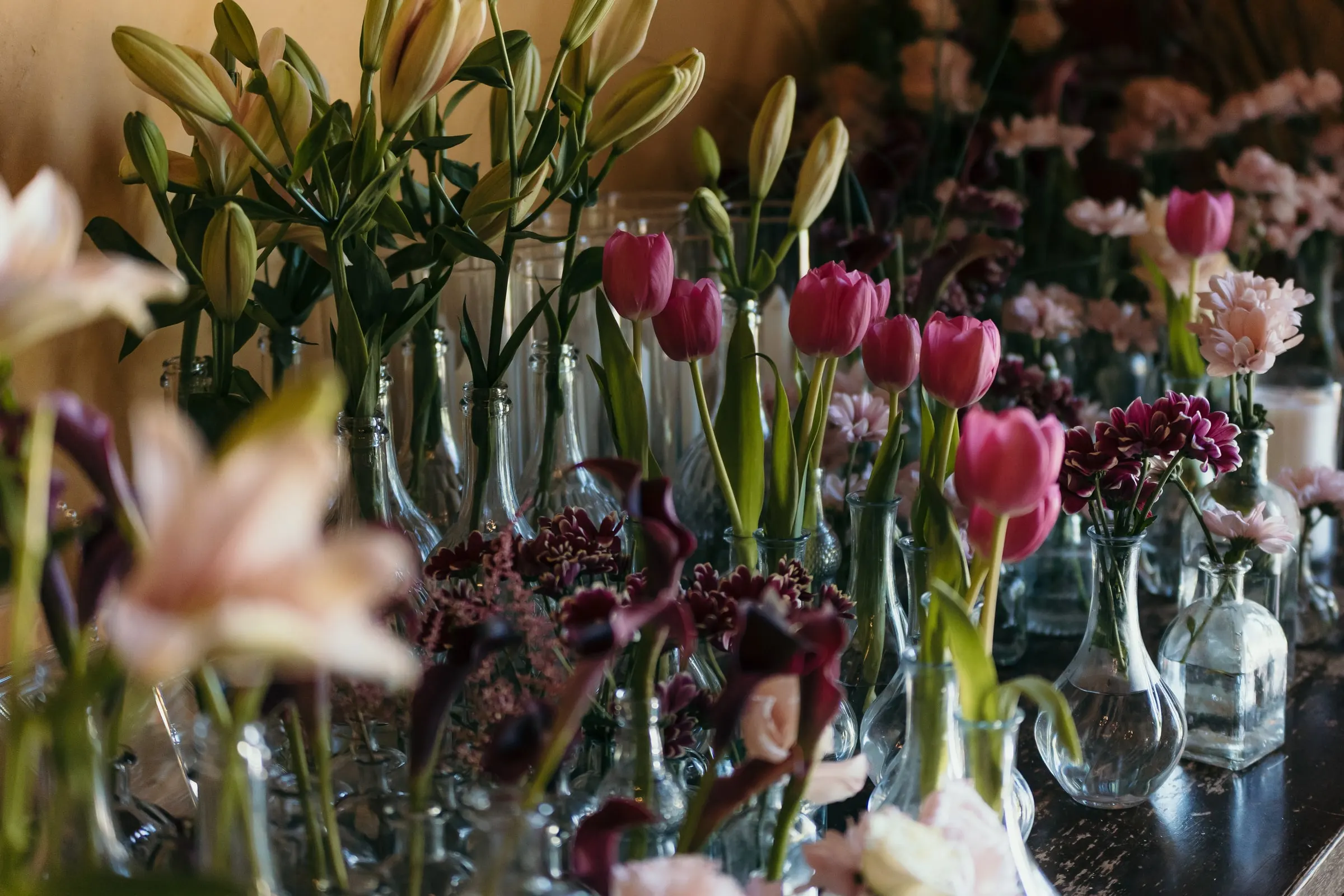 Vases of pink tulips, lilies and dark calla lilies crowded on a table, Hacienda San José, Mijas