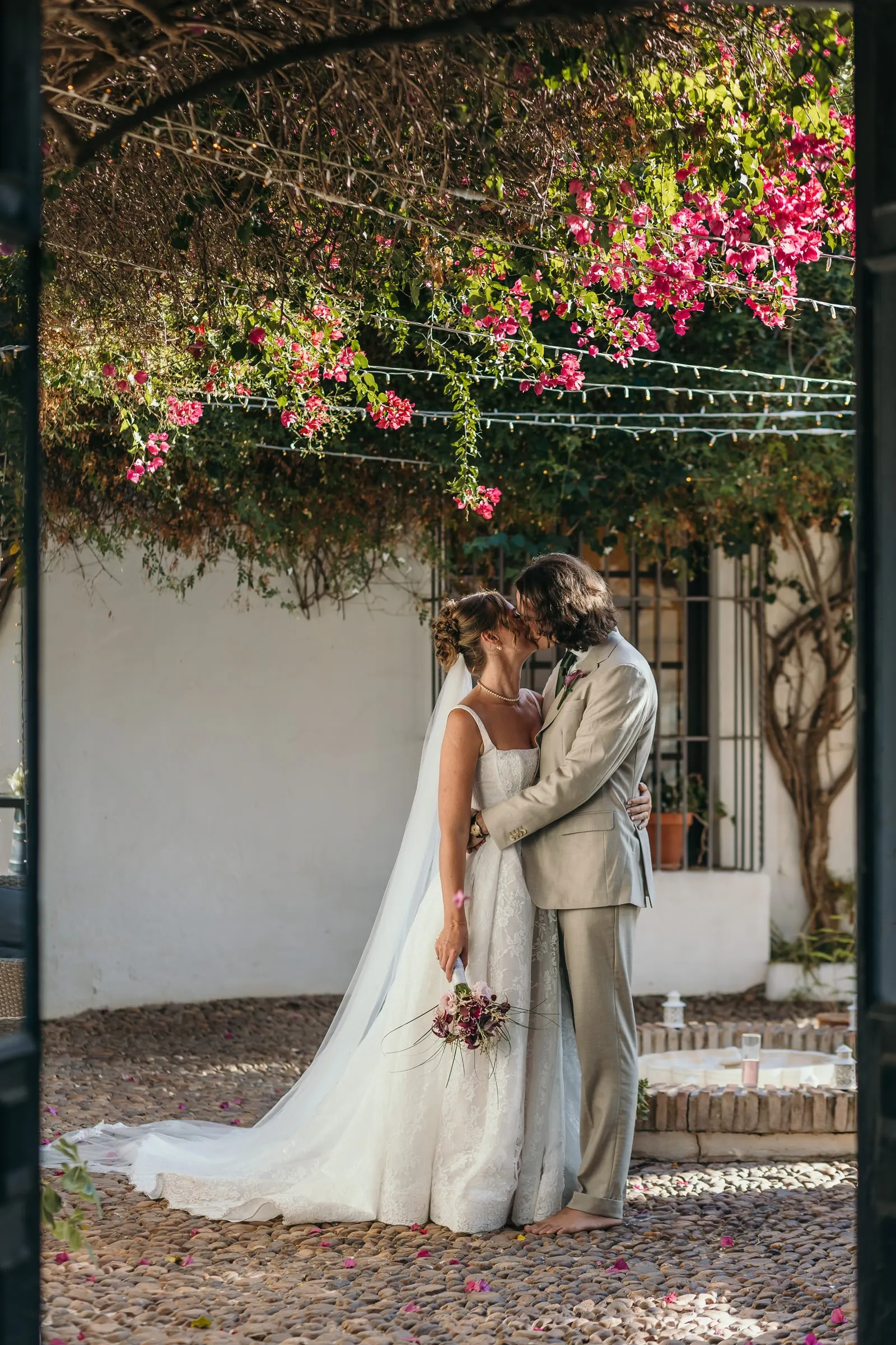 The couple embracing in a courtyard under pink bougainvillea, Hacienda San José, Mijas