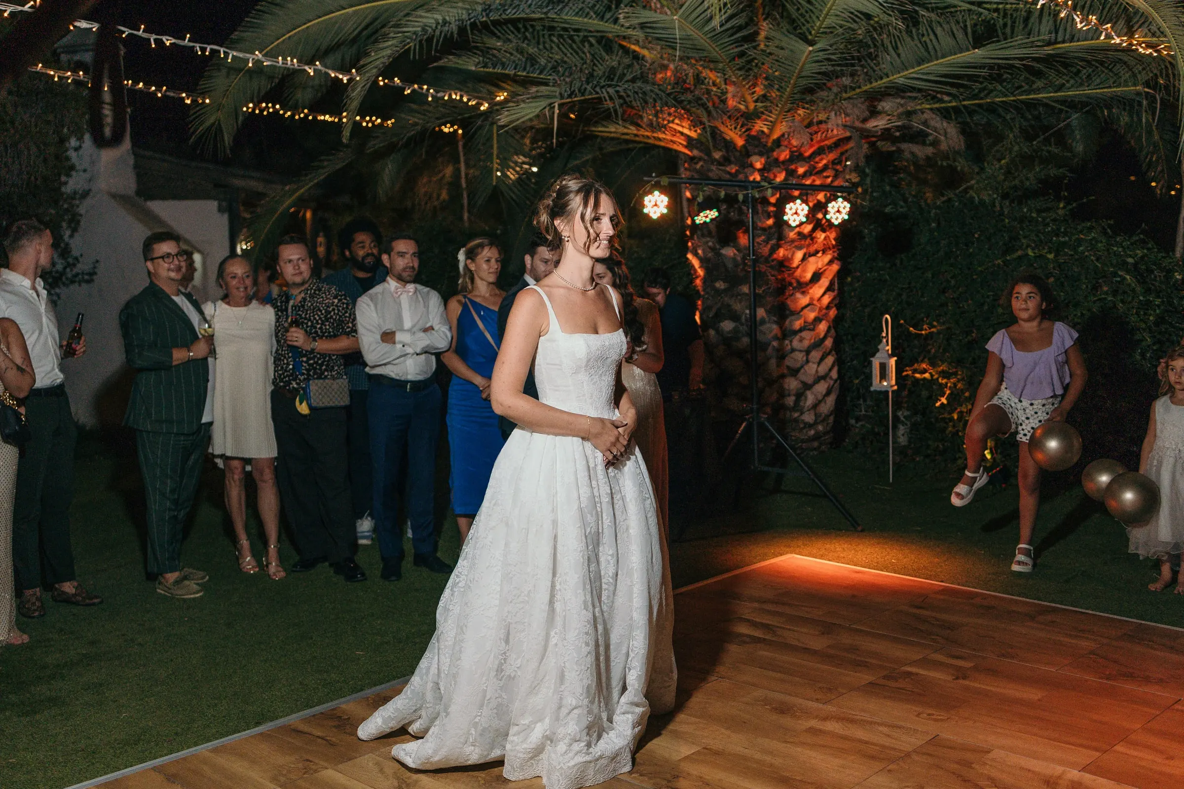 Bride on the dance floor at night as guests watch, at Hacienda San José, Mijas