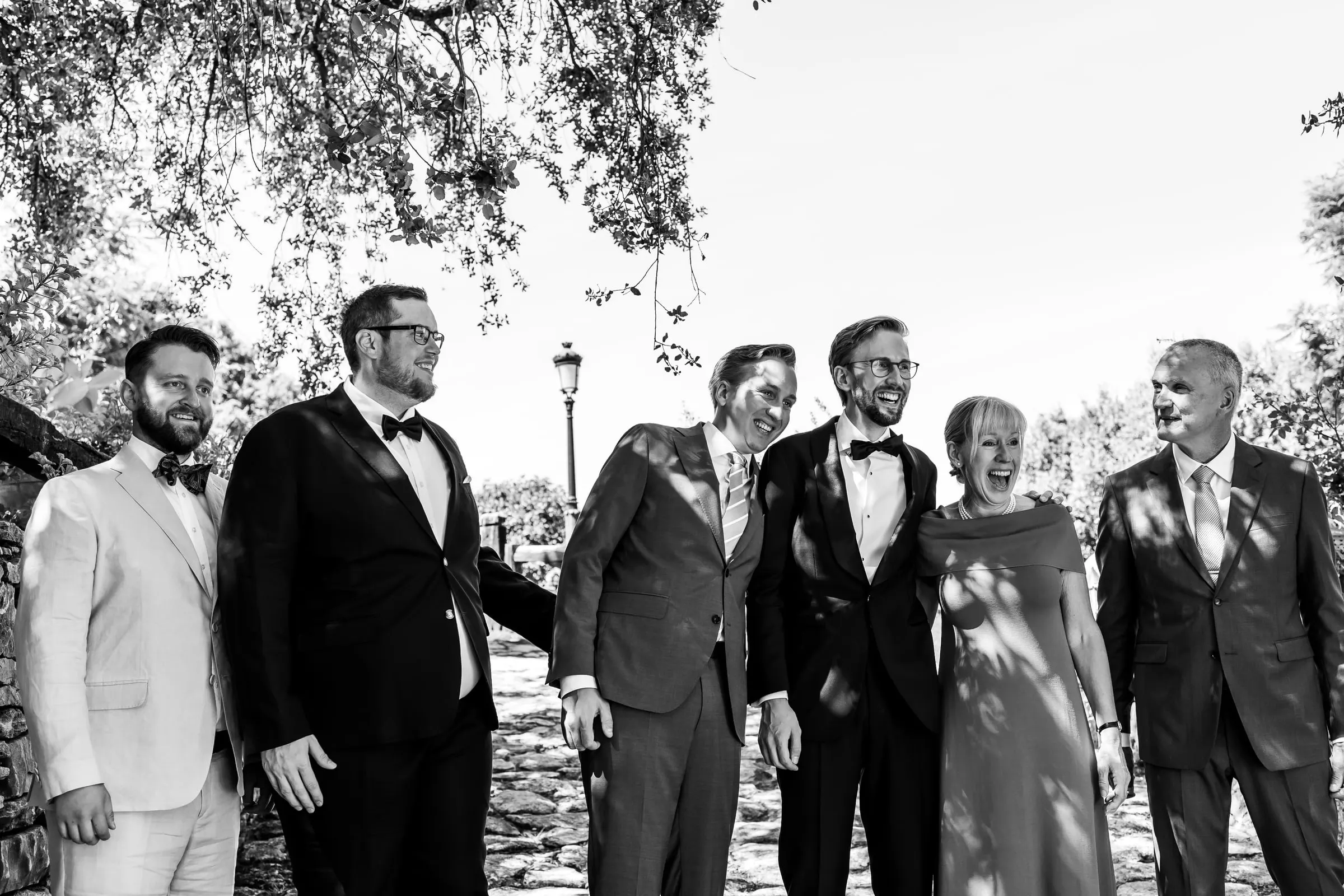 Retrato en blanco y negro del novio con sus amigos y su familia en un camino soleado de Ronda