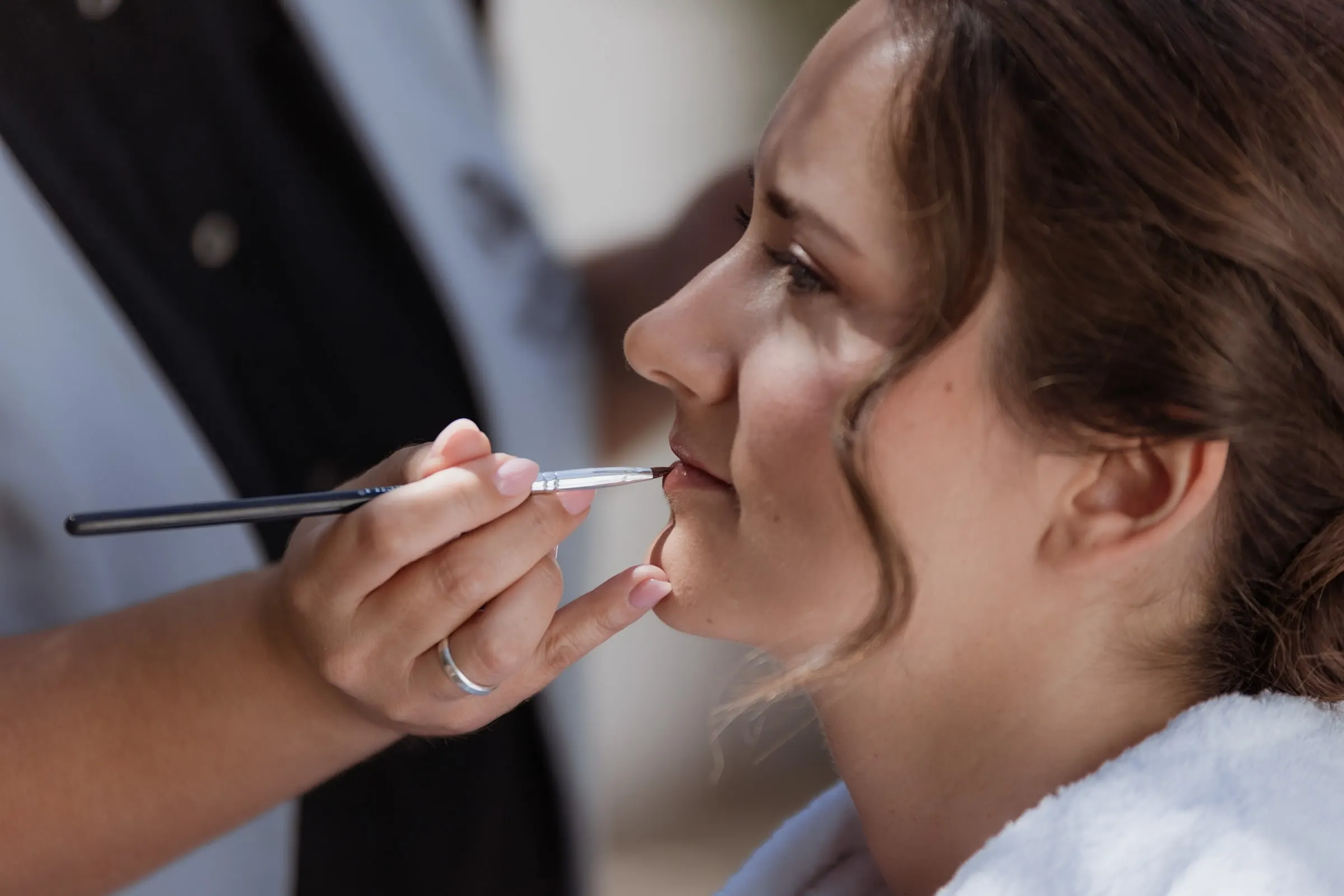 La maquilladora pinta los labios a la novia antes de su boda en Ronda
