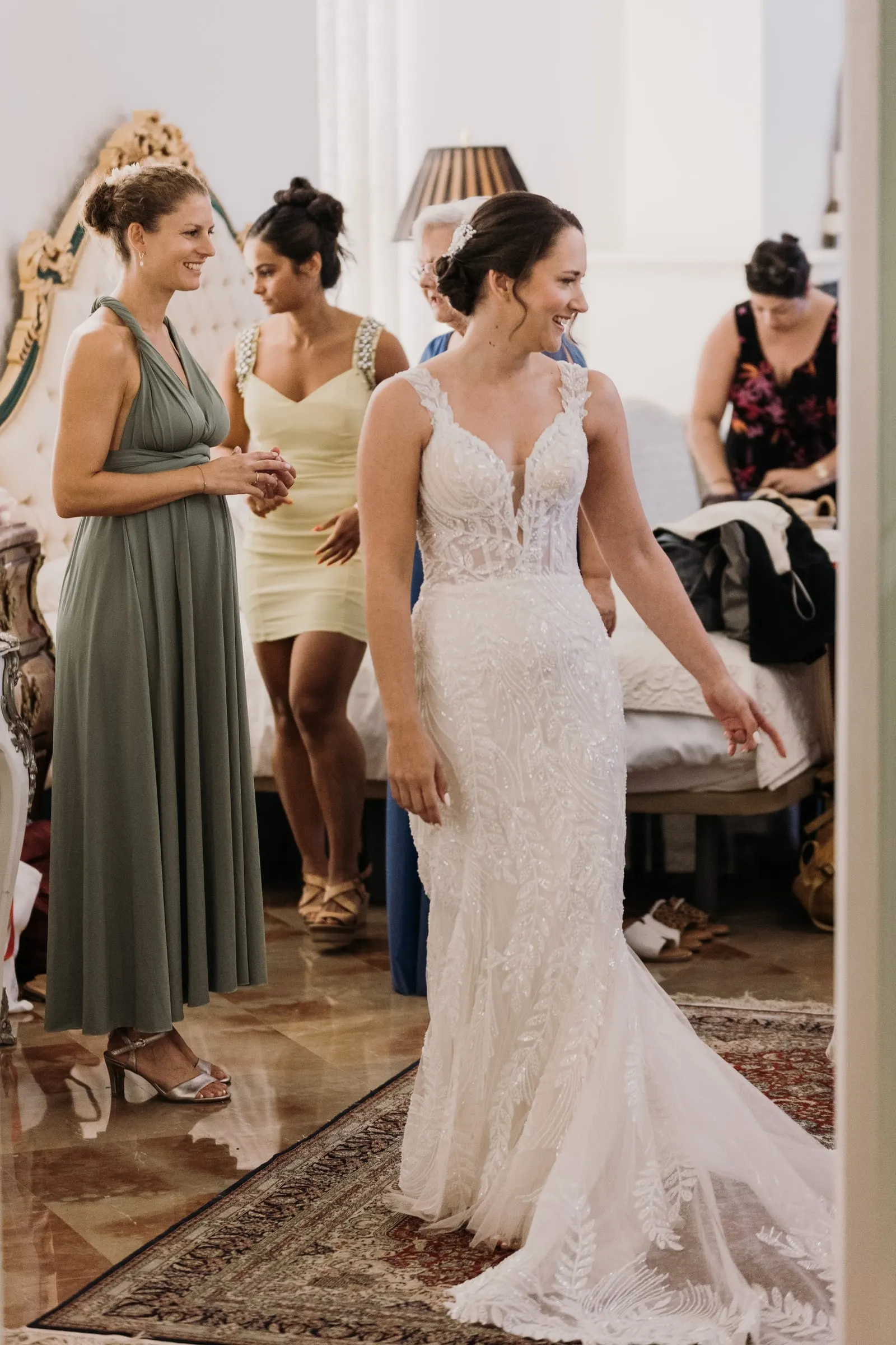 La novia con su vestido de encaje rodeada de amigas en la habitación nupcial en Ronda