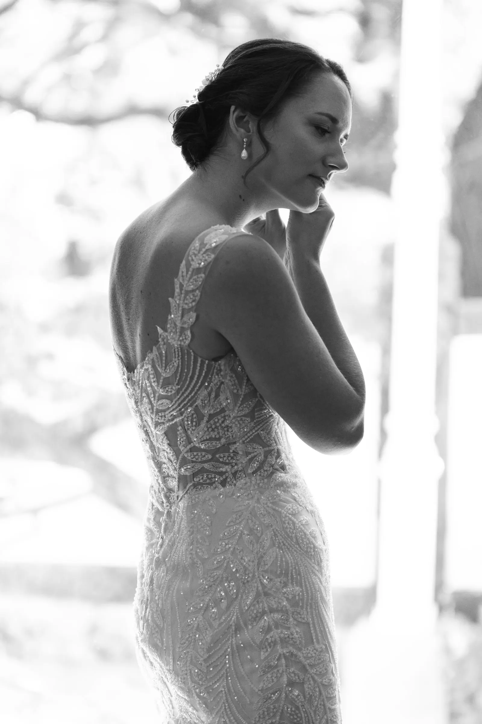 Perfil en blanco y negro de la novia con la espalda de encaje del vestido