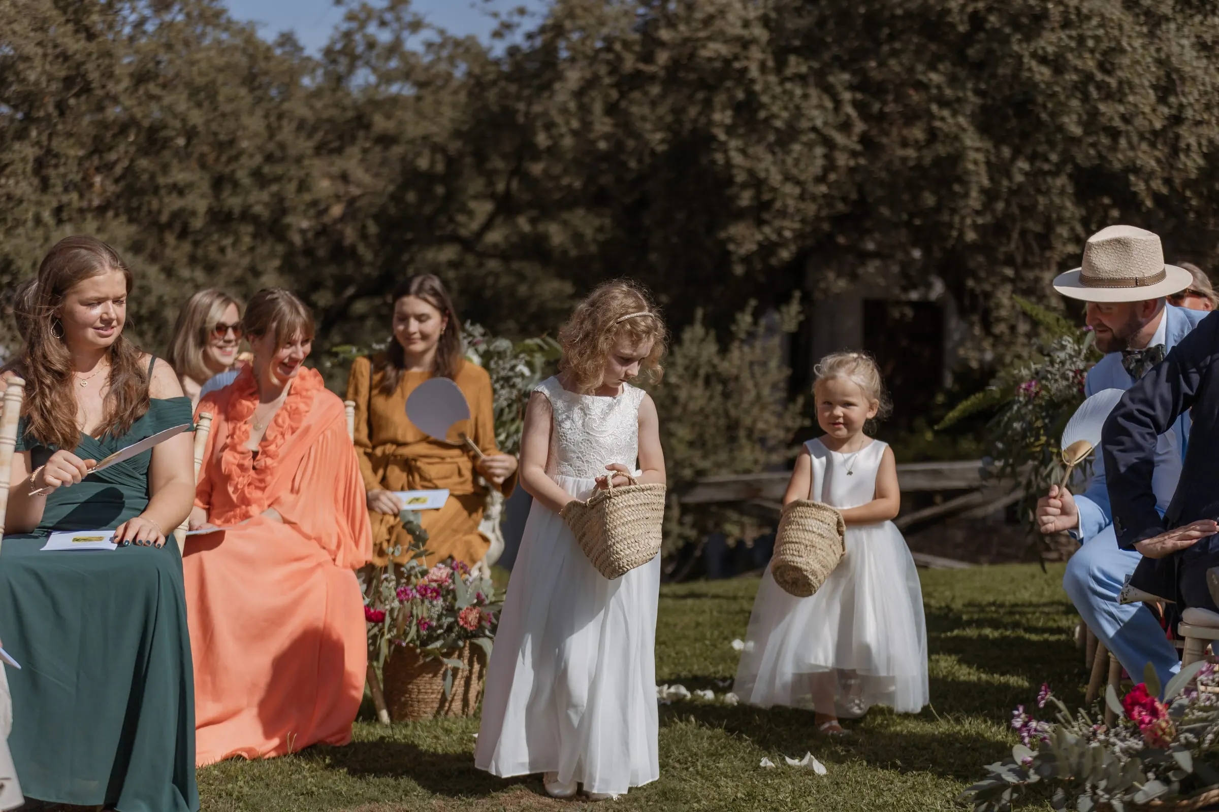 Las niñas de las flores recorren el pasillo con sus cestas en el jardín