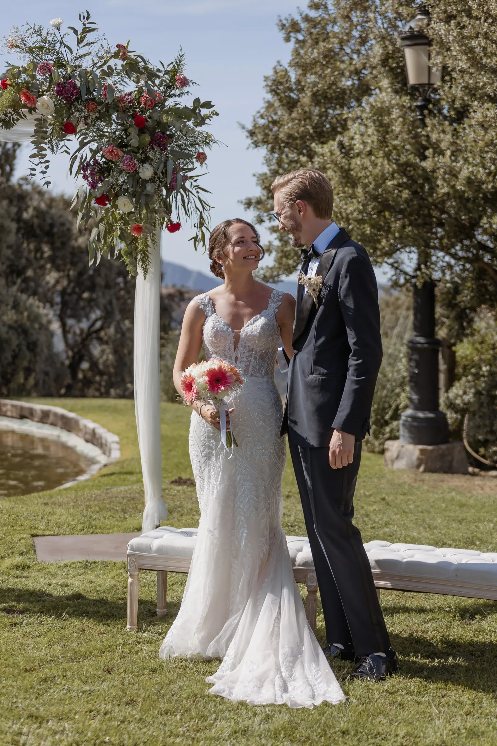 Los novios se ríen bajo el arco de flores en su ceremonia en Ronda
