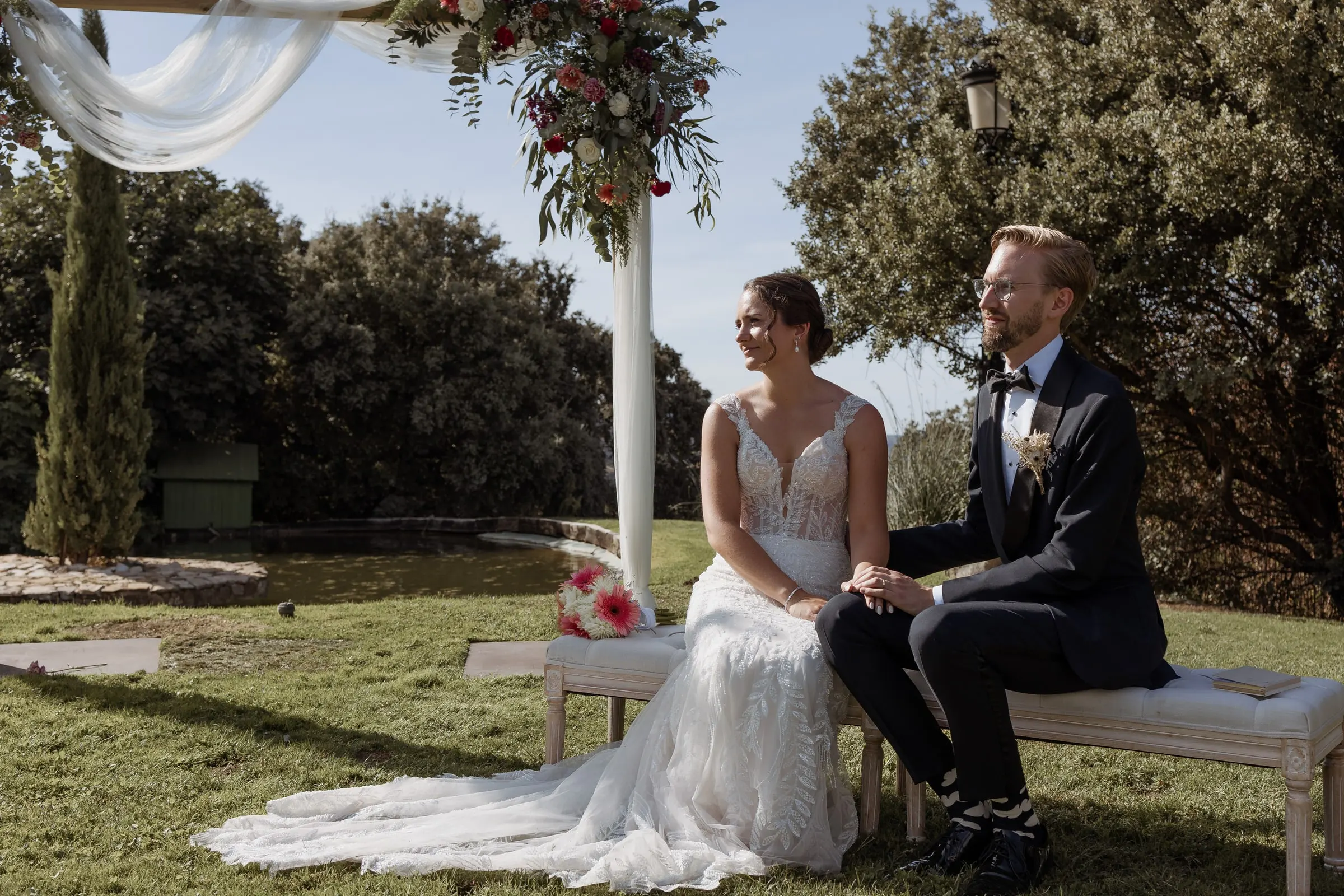 Los novios sentados en un banco bajo el arco durante la ceremonia en Ronda