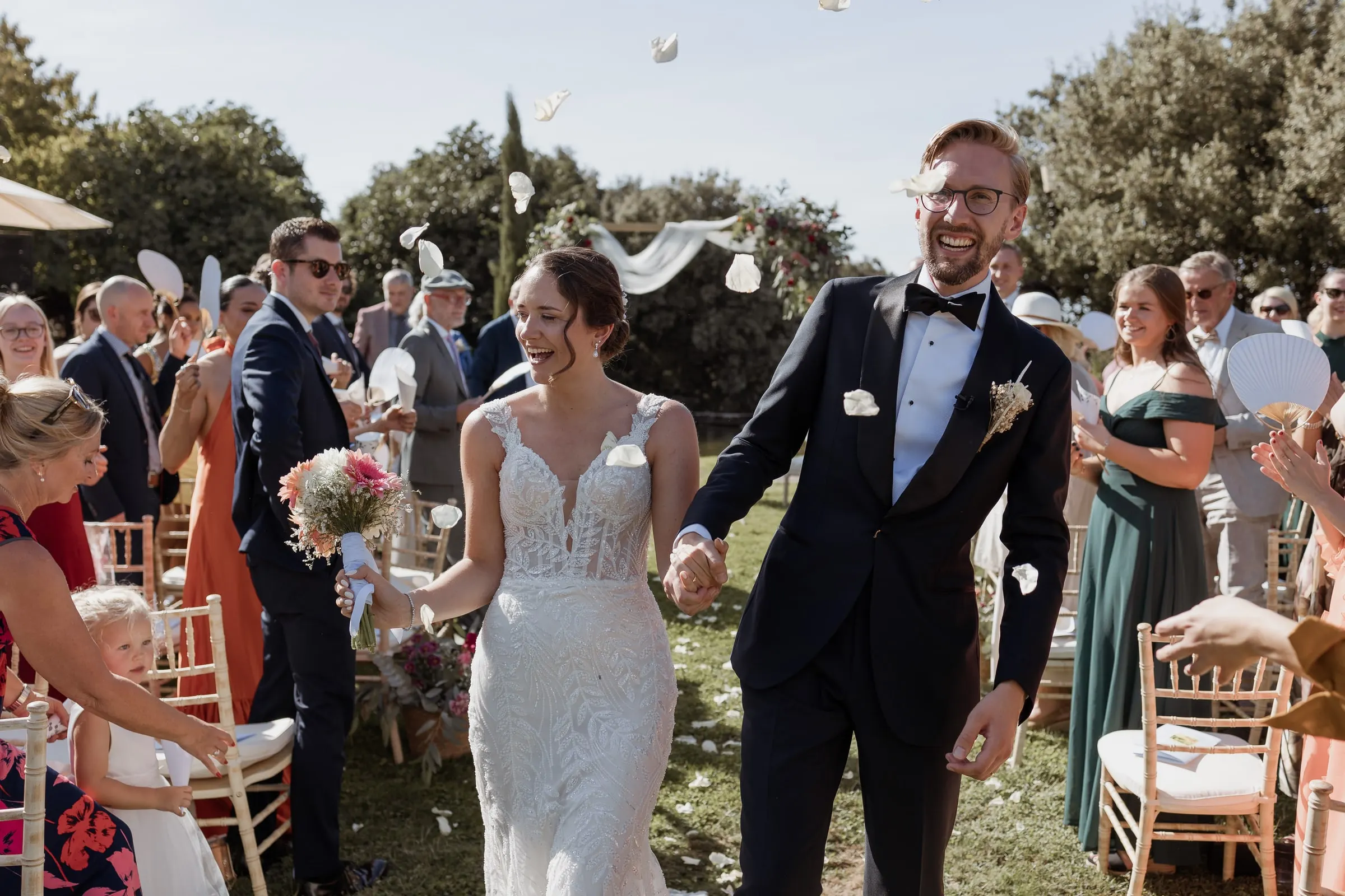 Los recién casados vuelven por el pasillo mientras los invitados lanzan pétalos