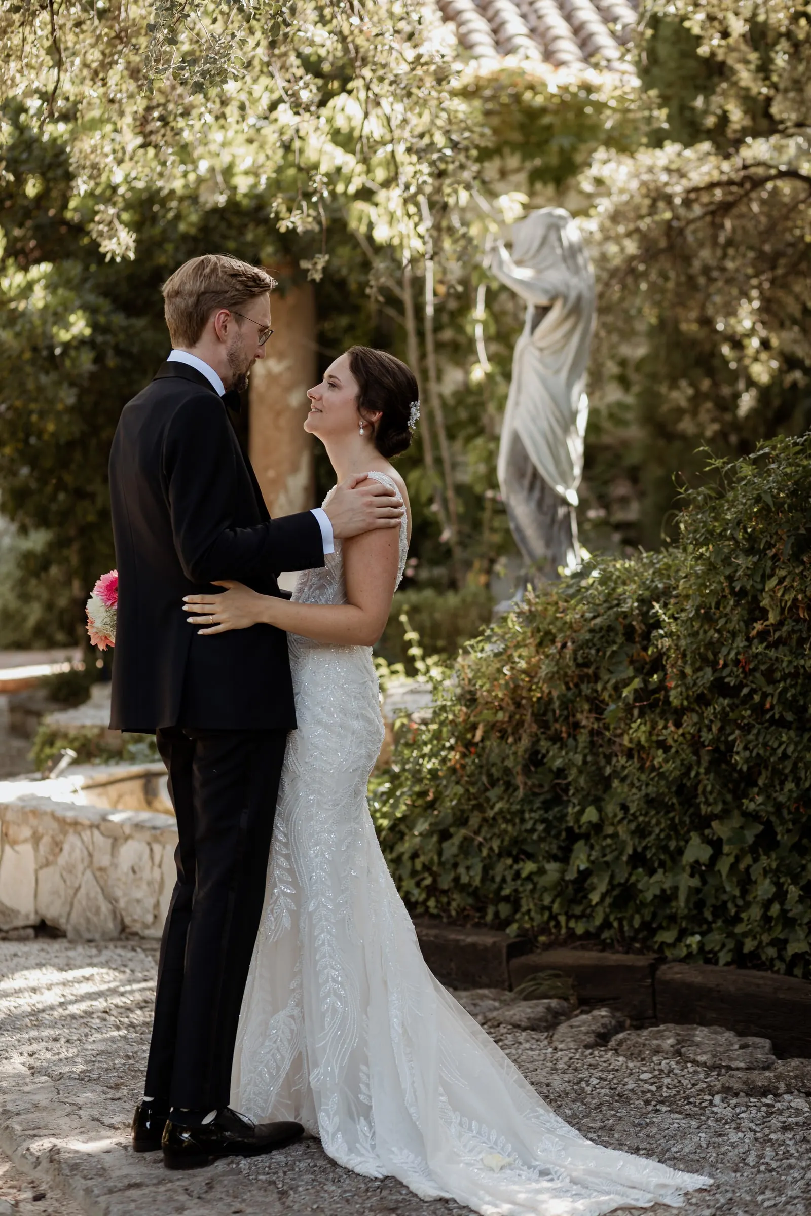 La pareja abrazada junto a una estatua blanca en el jardín de la finca de Ronda
