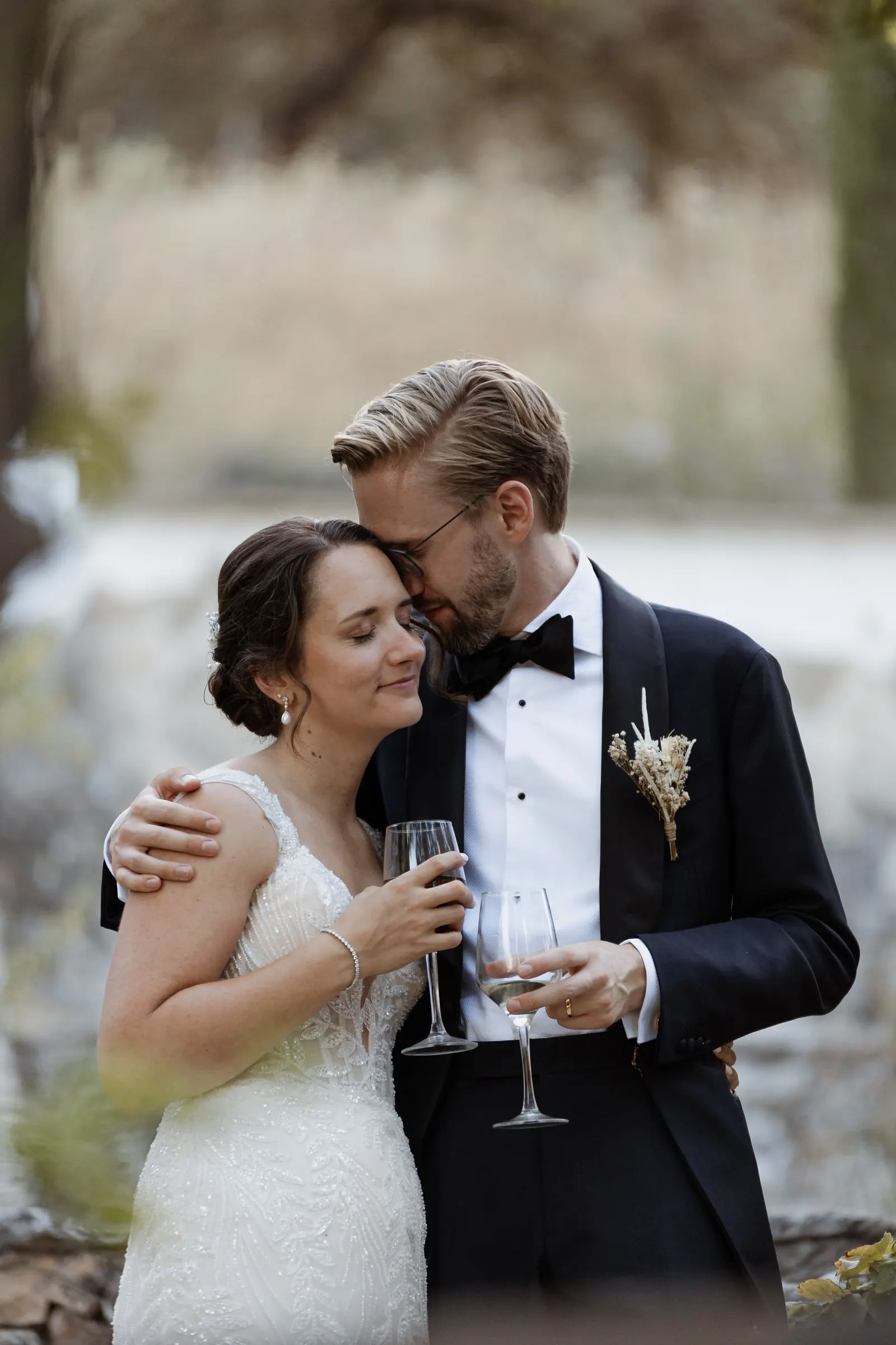 Los novios abrazados con sus copas de cava tras la ceremonia