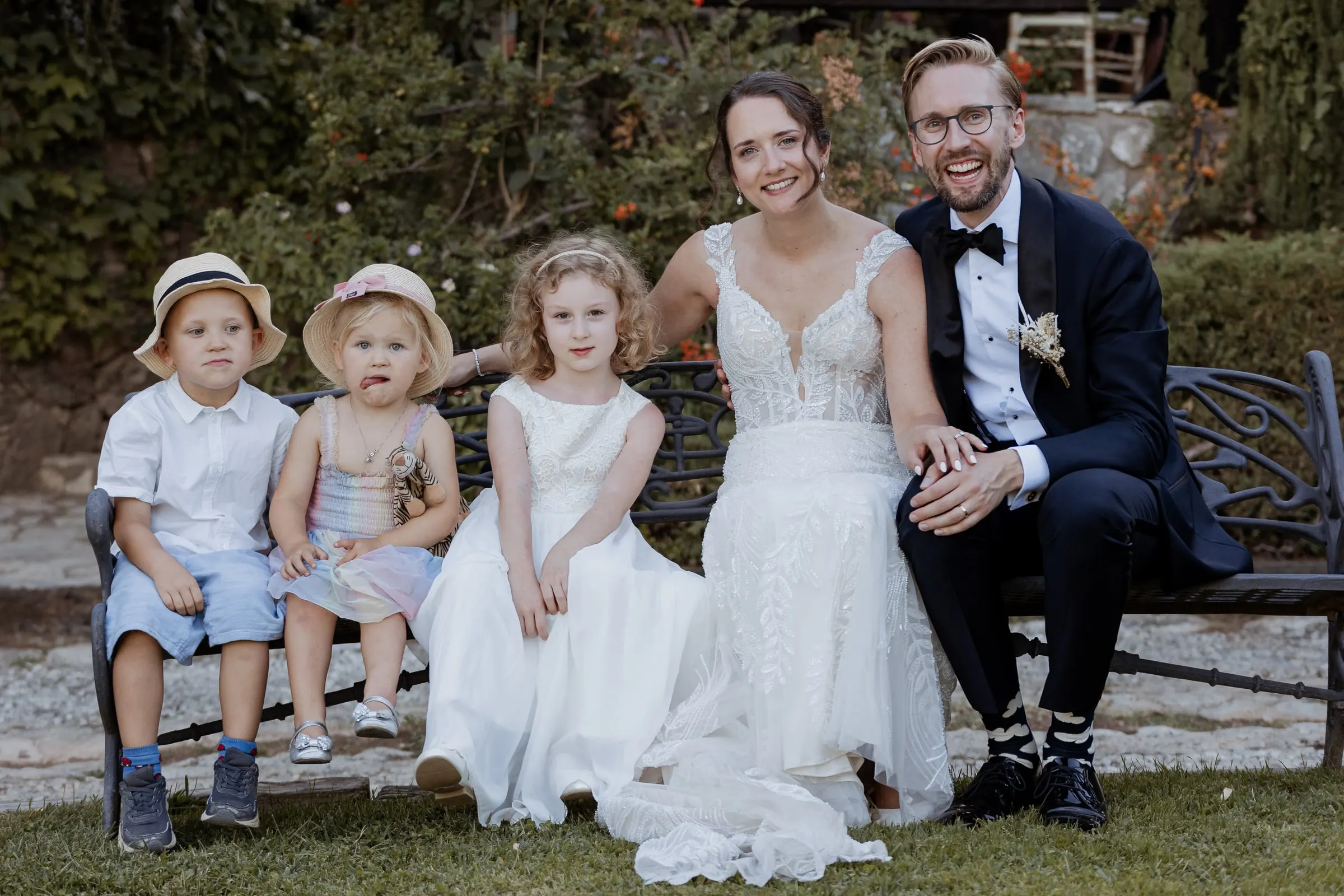 Los novios en un banco del jardín con el paje y las niñas de las flores