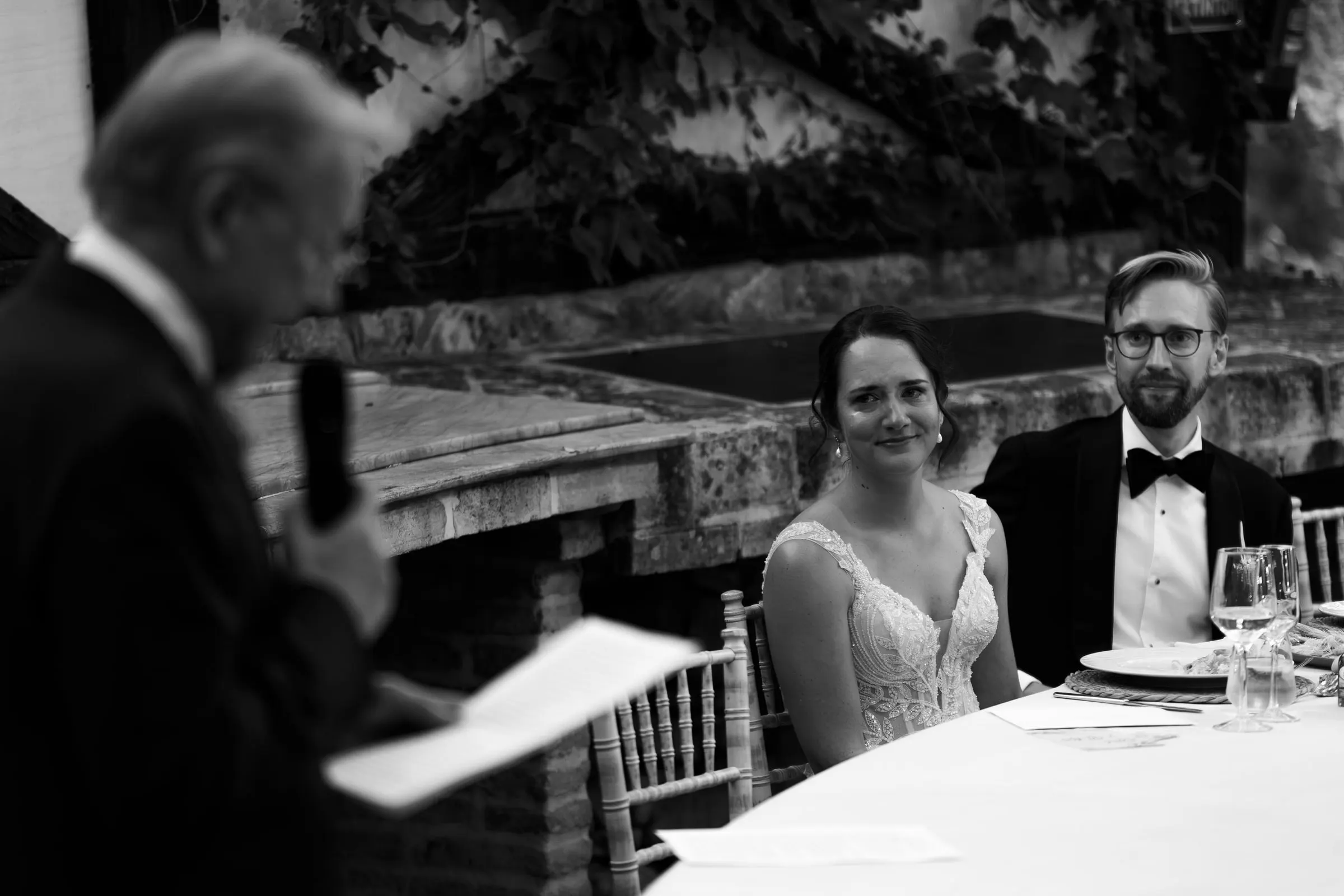 Foto en blanco y negro de un discurso familiar mientras la pareja escucha en la mesa