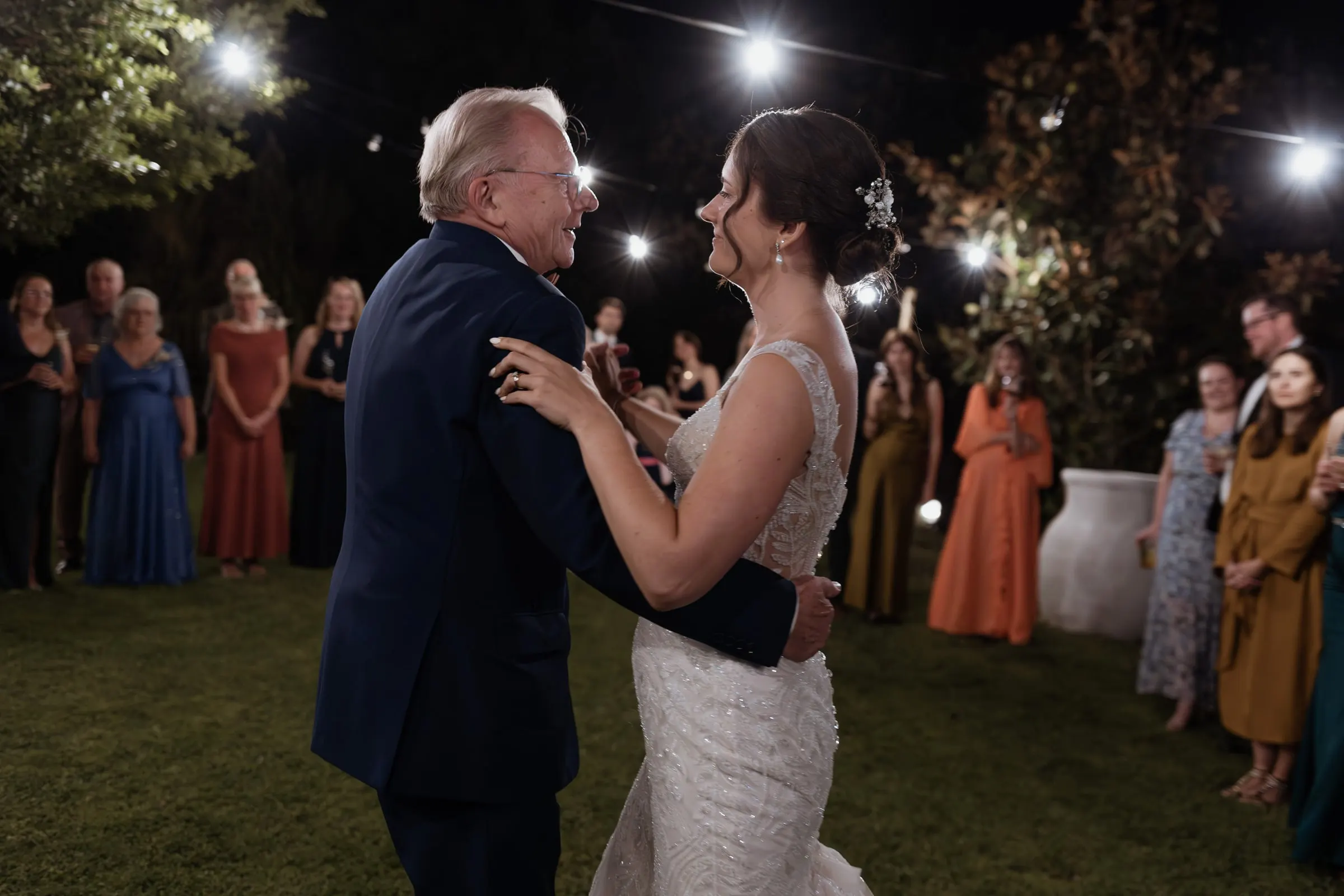 La novia baila con un invitado mayor de traje azul marino