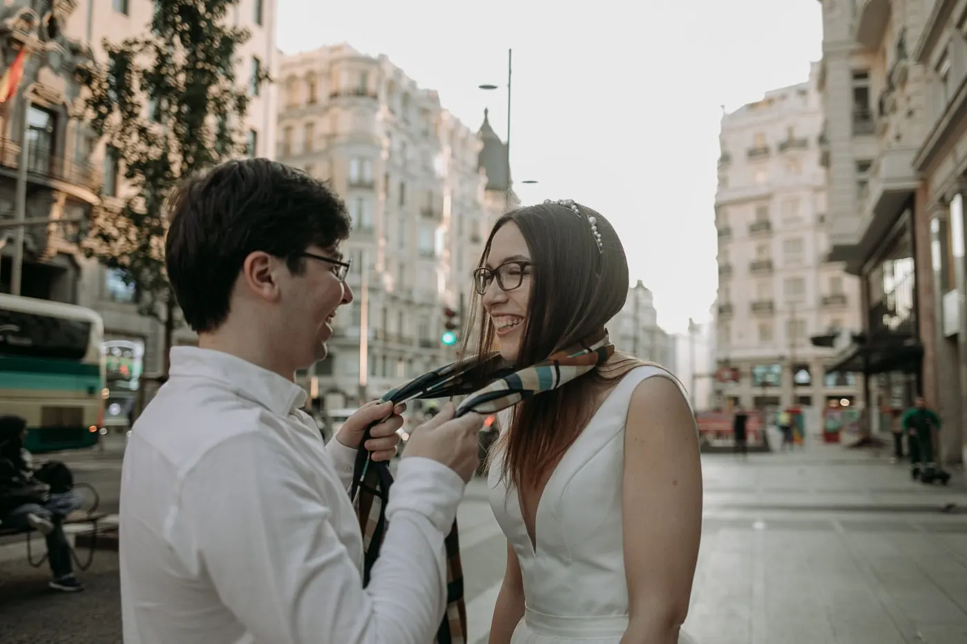 El novio le anuda una bufanda de rayas a la novia en la Gran Vía, Madrid
