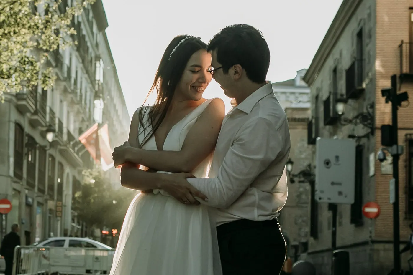 Los novios se abrazan a contraluz en una calle estrecha de Madrid
