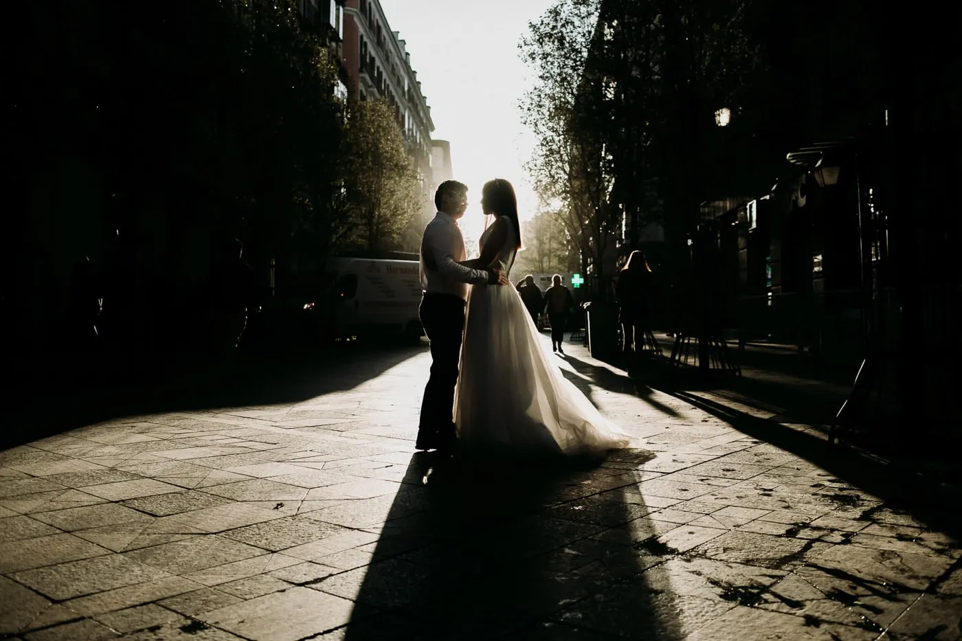 Silueta de los novios en una calle empedrada con sombras largas