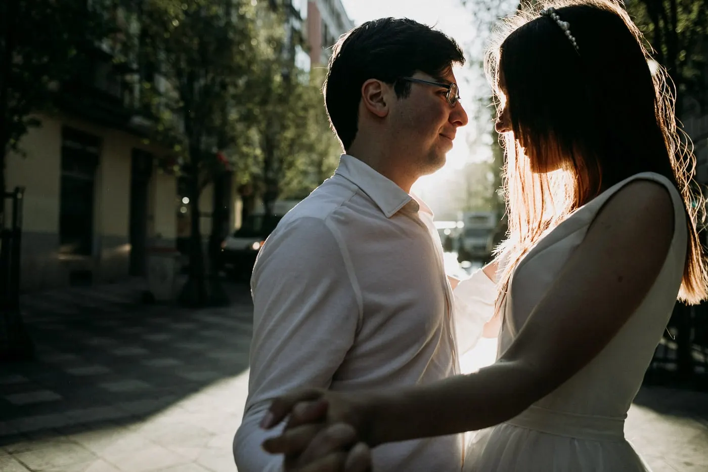 Los novios frente a frente a contraluz, con el sol en el pelo de ella