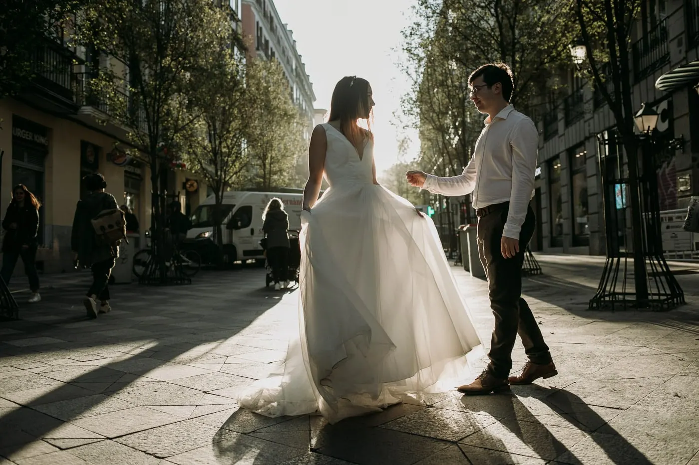 El novio hace girar a la novia en una acera soleada del centro de Madrid